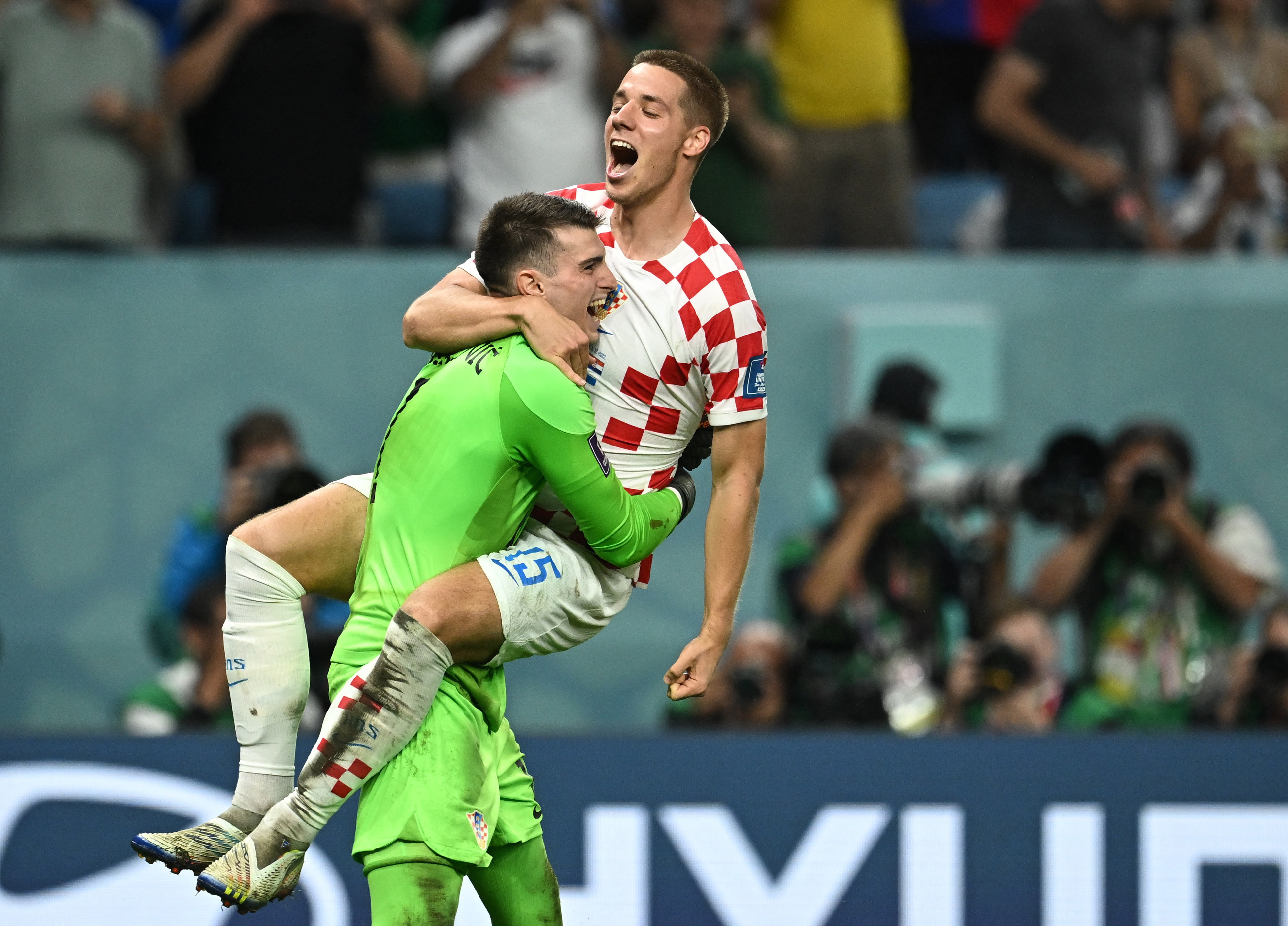 Croatia's Mario Pasalic celebrates with teammate Dominik Livakovic after scoring the winning penalty during the penalty shootout