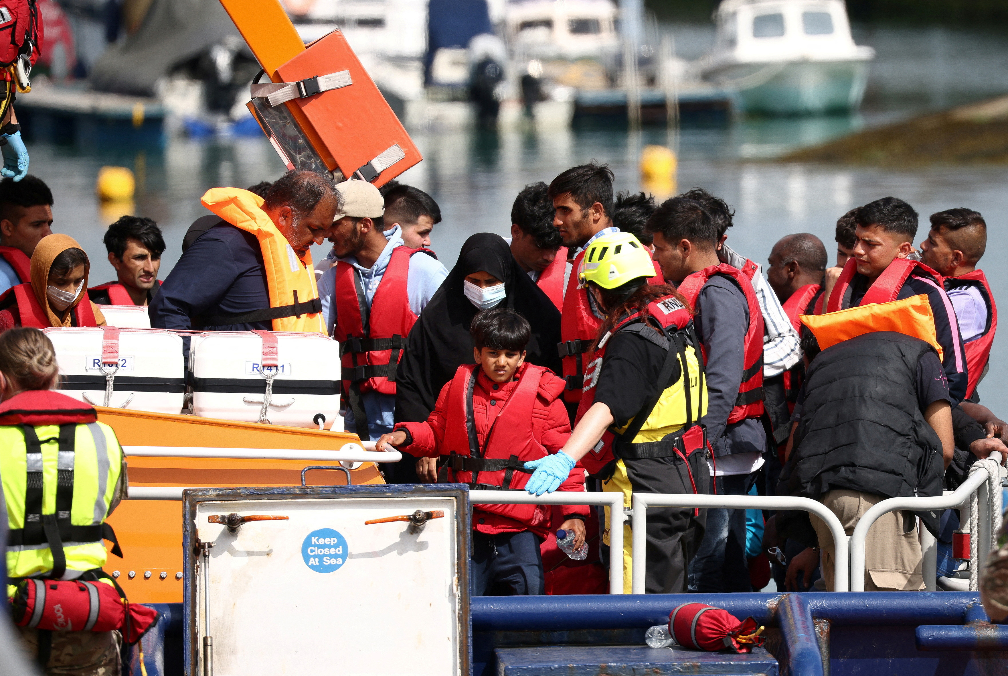 Refugees and migrants arrive at the UK's Dover Harbour on board a Border Force vessel.