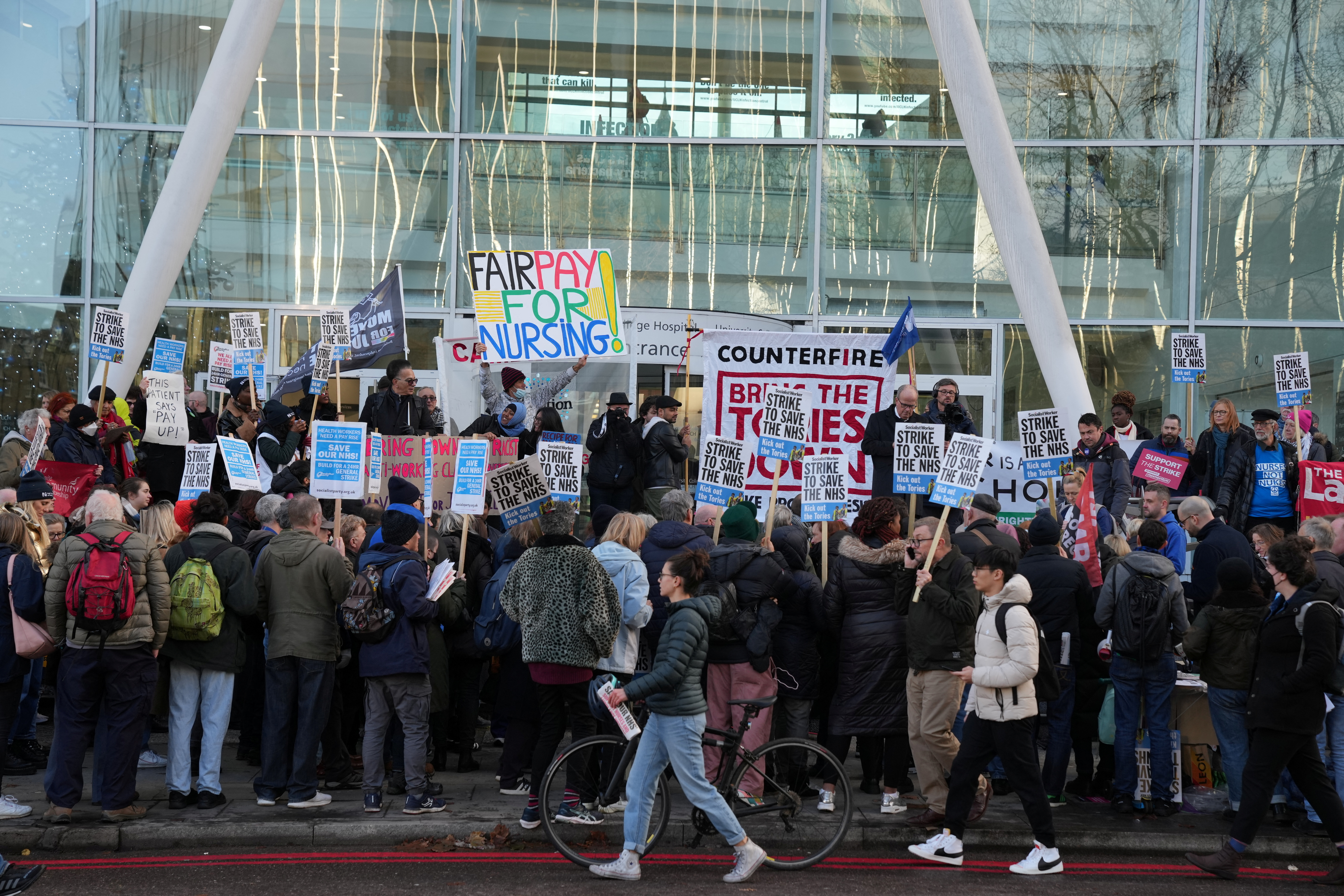 People hold signs outside University College Hospital as NHS nurses march