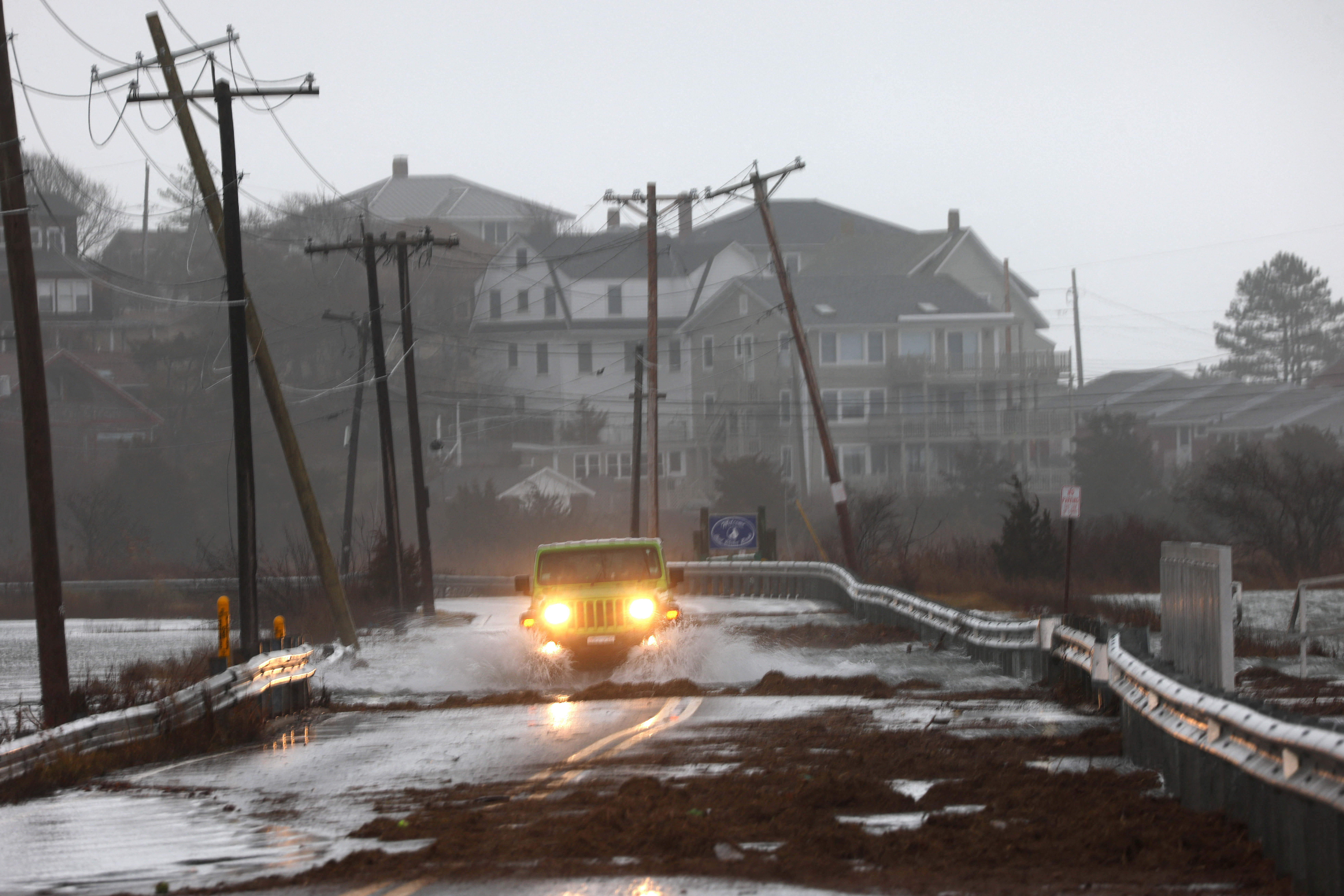 A driver makes their way through a flooded street