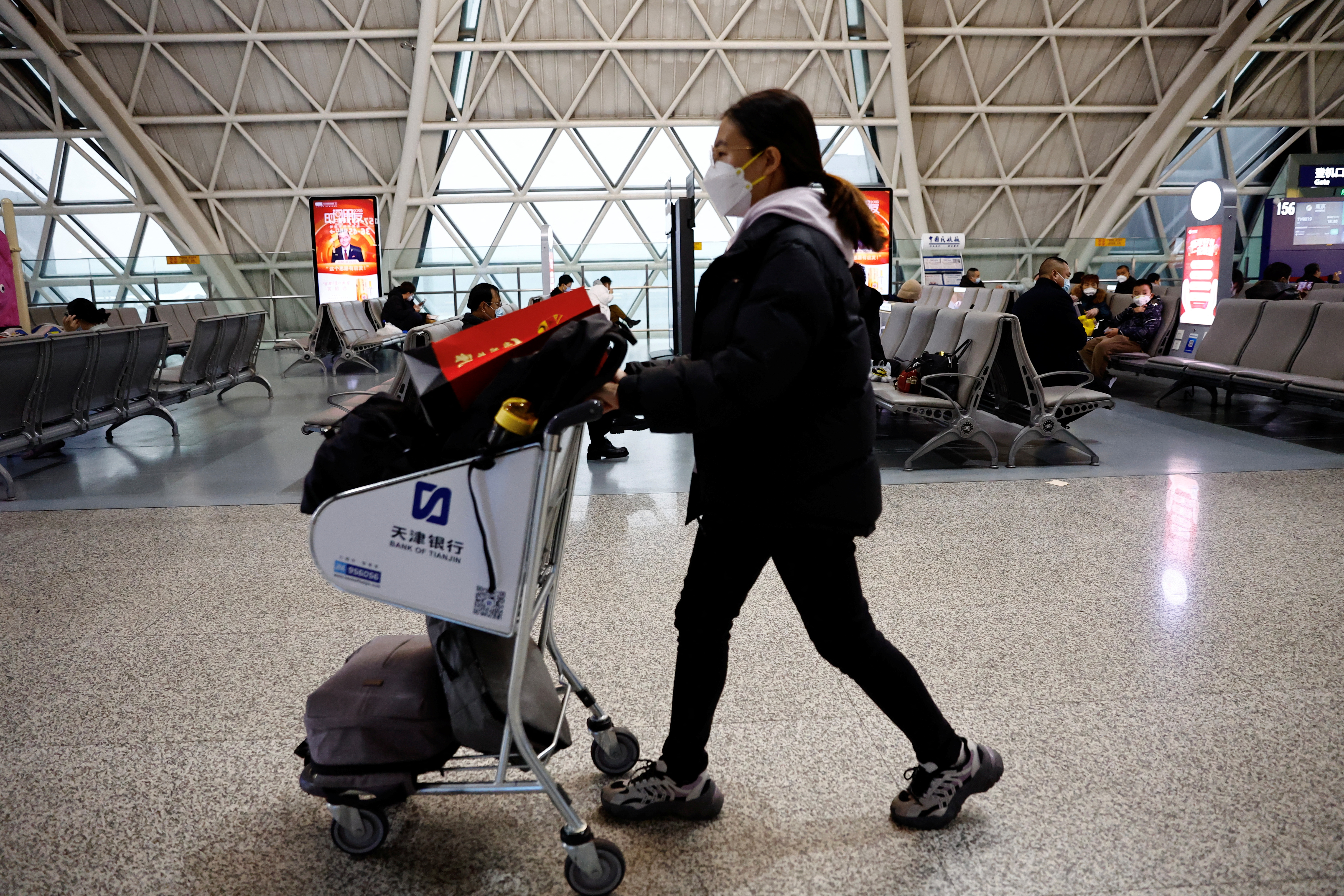 A traveller pushes a luggage cart at Chengdu Shuangliu International Airport