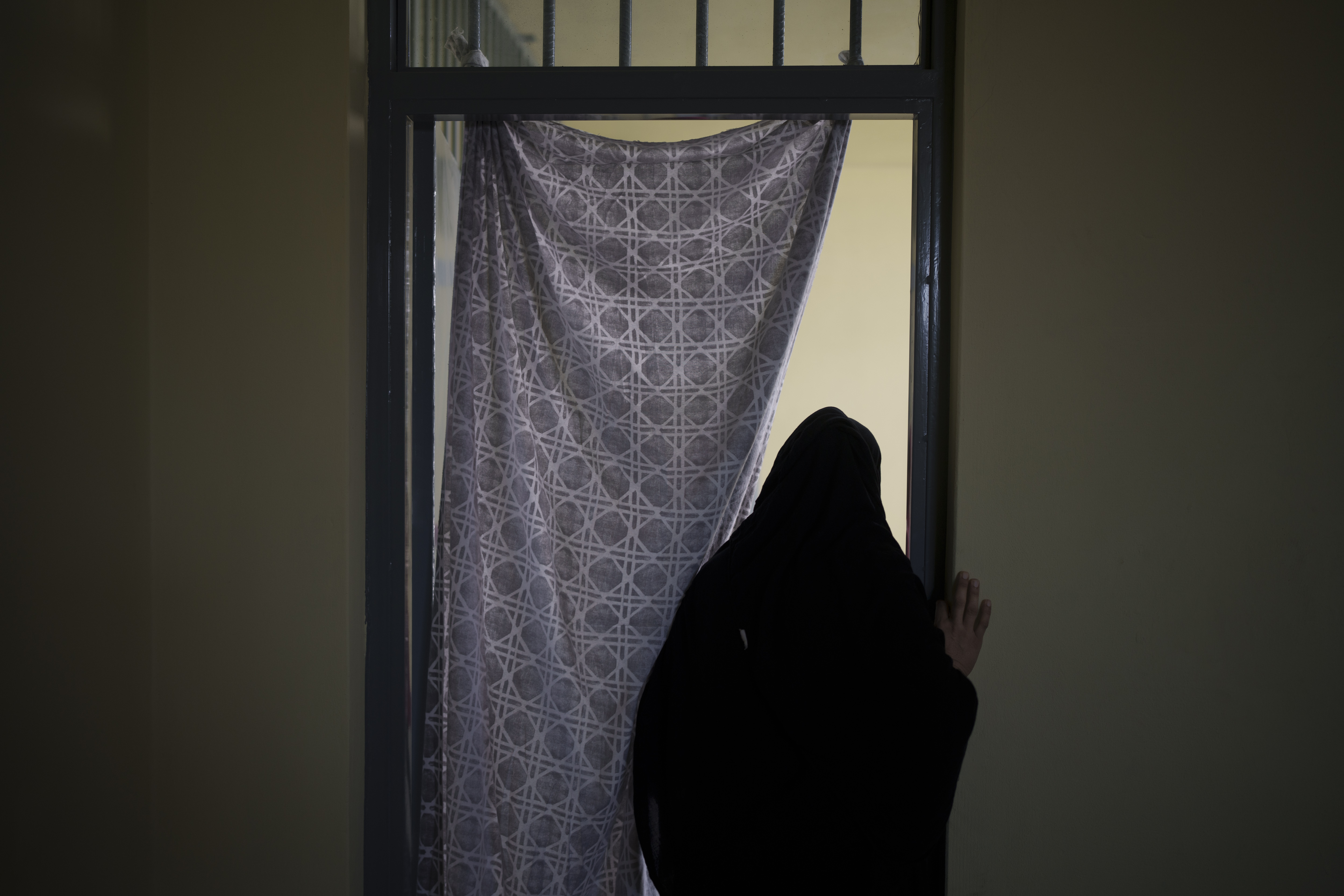 An Afghan woman walks out of a cell inside the women's section of the Pul-e-Charkhi prison in Kabul, Afghanistan