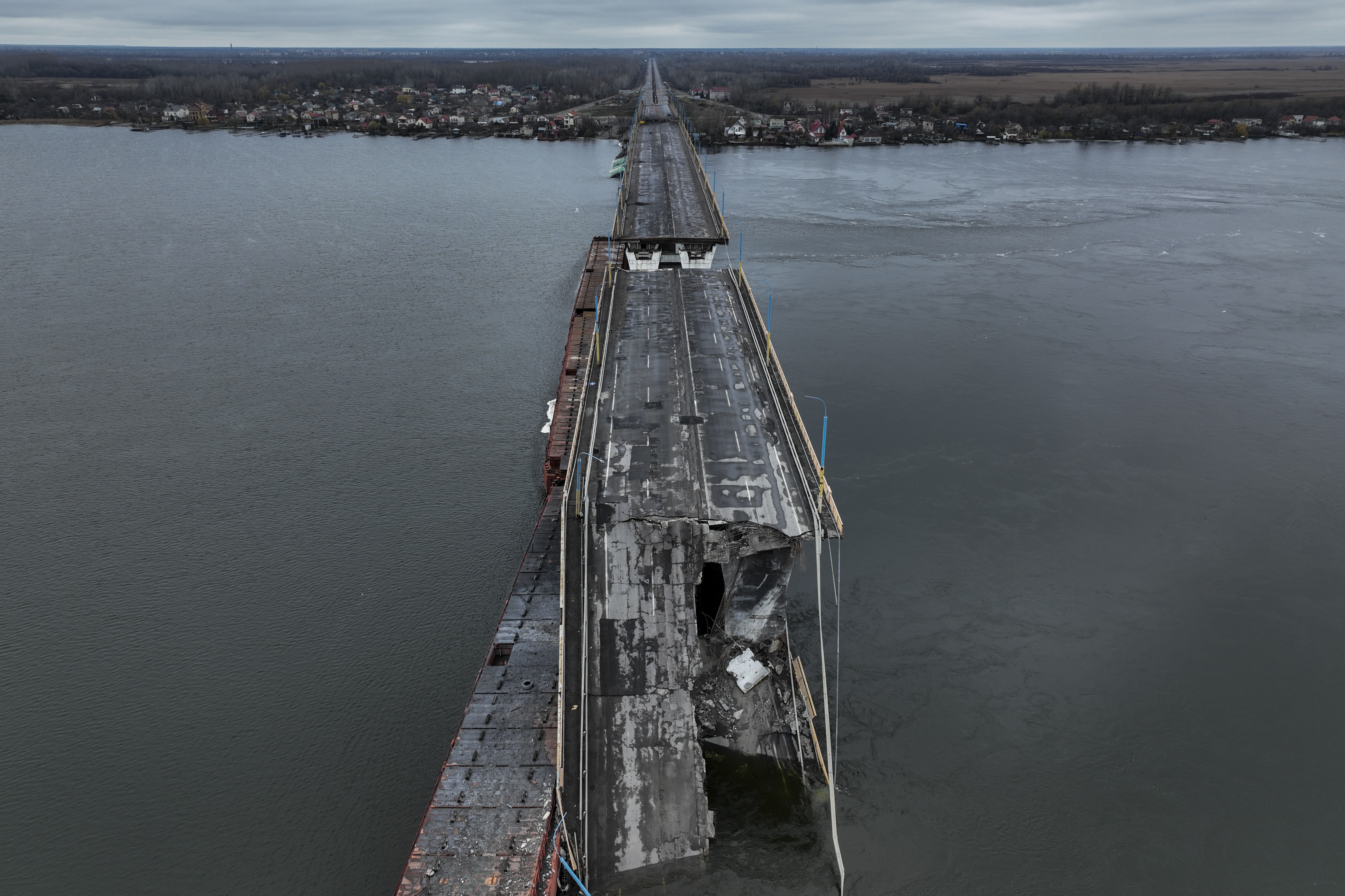 The damaged Antonivsky Bridge is visible in Kherson, Ukraine, Sunday, Nov. 27, 2022. The bridge, the main crossing point over the Dnipro river in Kherson, was destroyed by Russian troops in earlier November, after Kremlin's forces withdrew from the southern city. (AP Photo/Bernat Armangue)