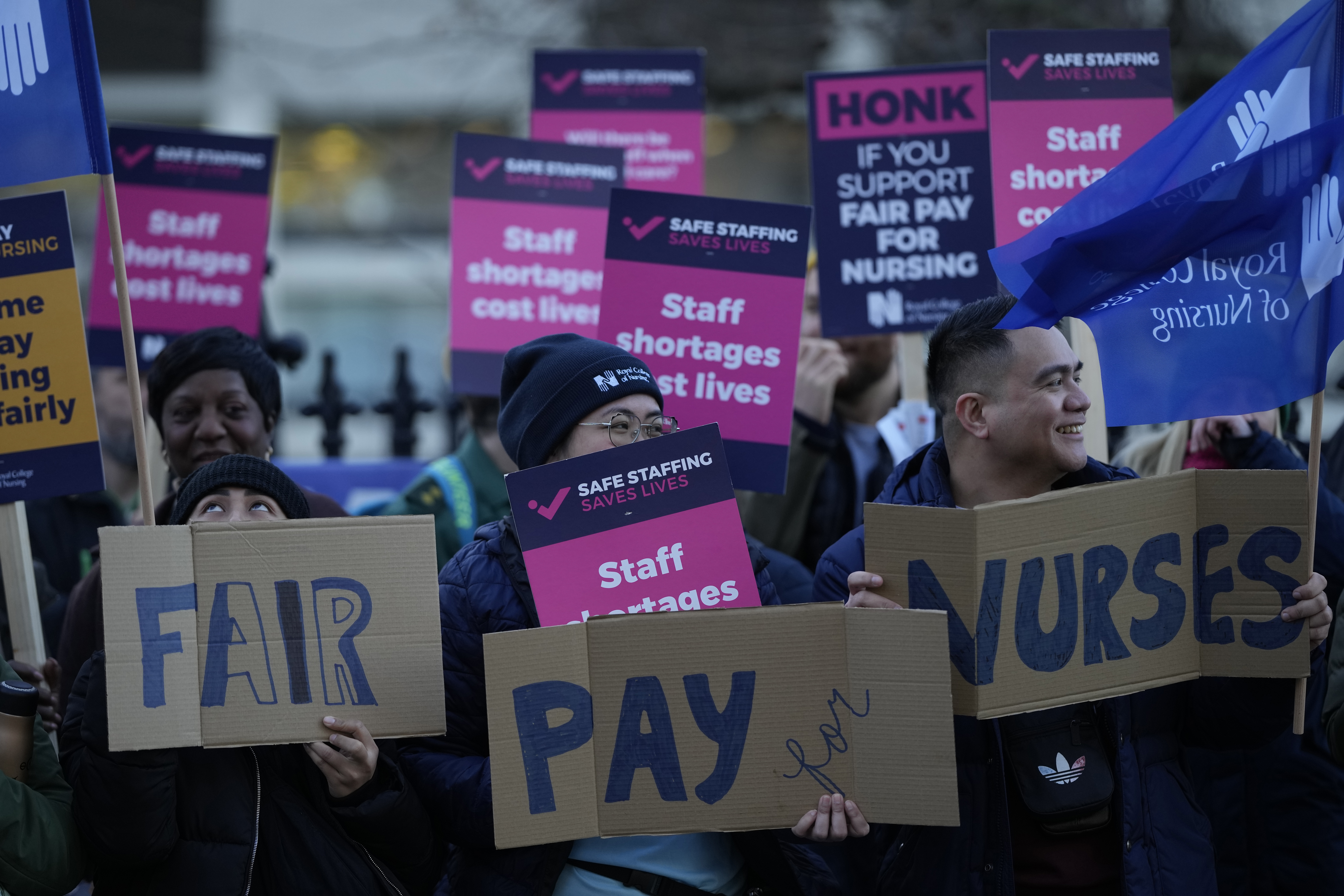 Demonstrators hold up placards in support of a strike by nurses