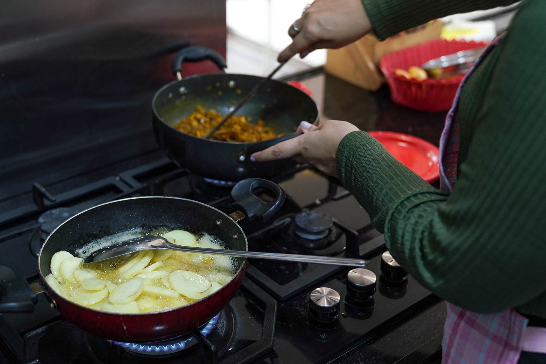 A view of Khushboo's hands at the stove as she prepares food