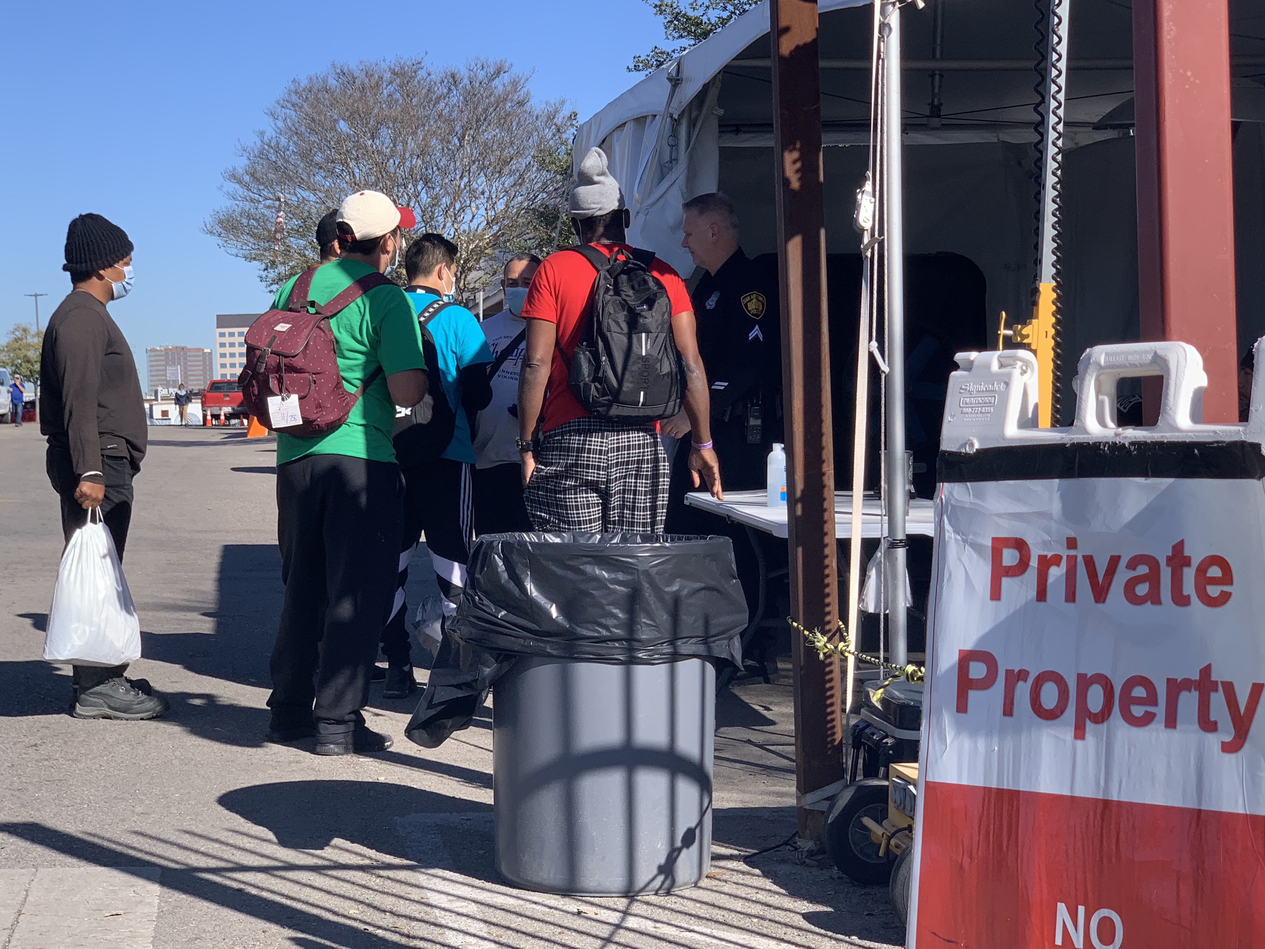 Migrants stand outside the San Antonio Migrant Resource Center in San Antonio, Texas