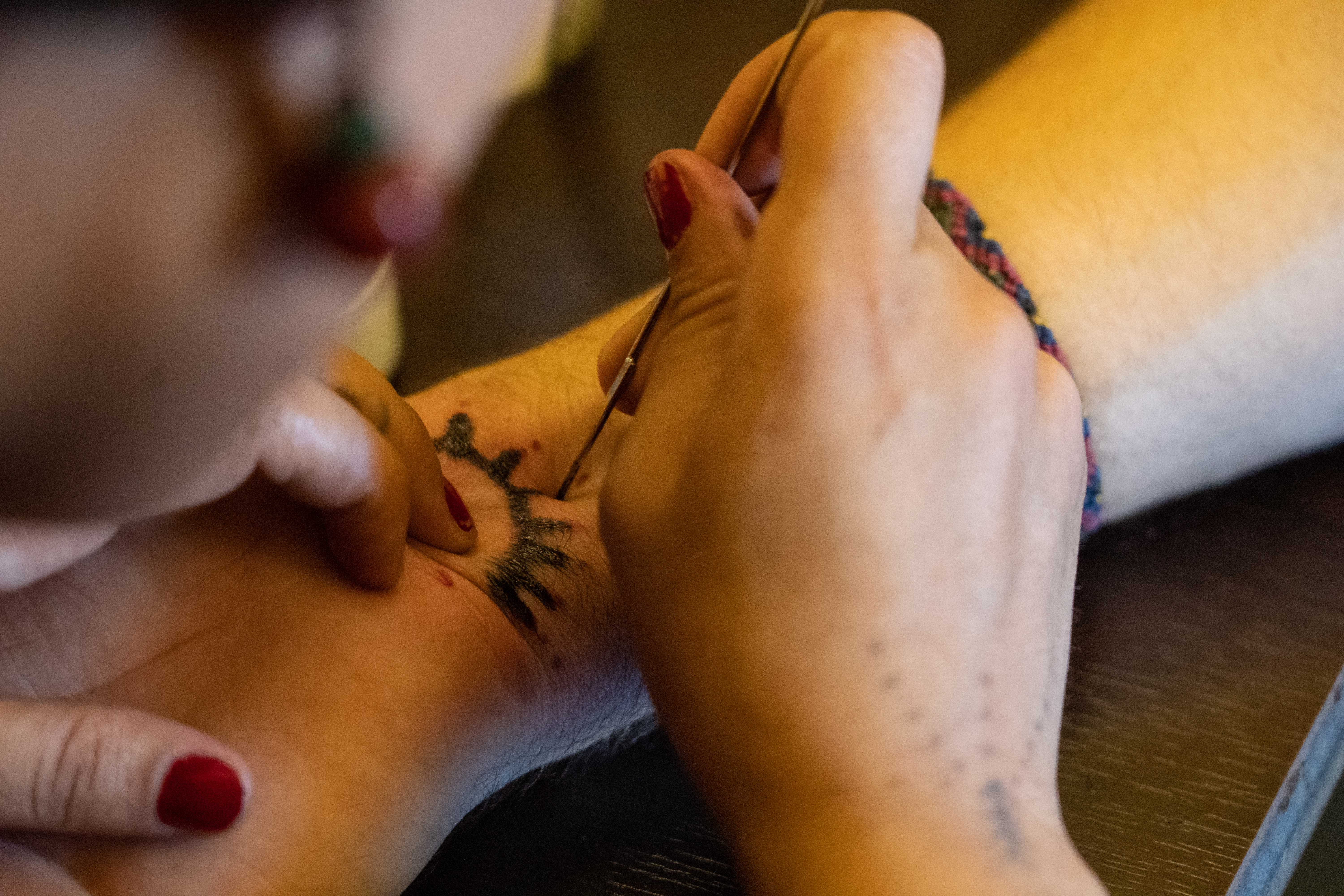 A woman giving someone a deq tattoo