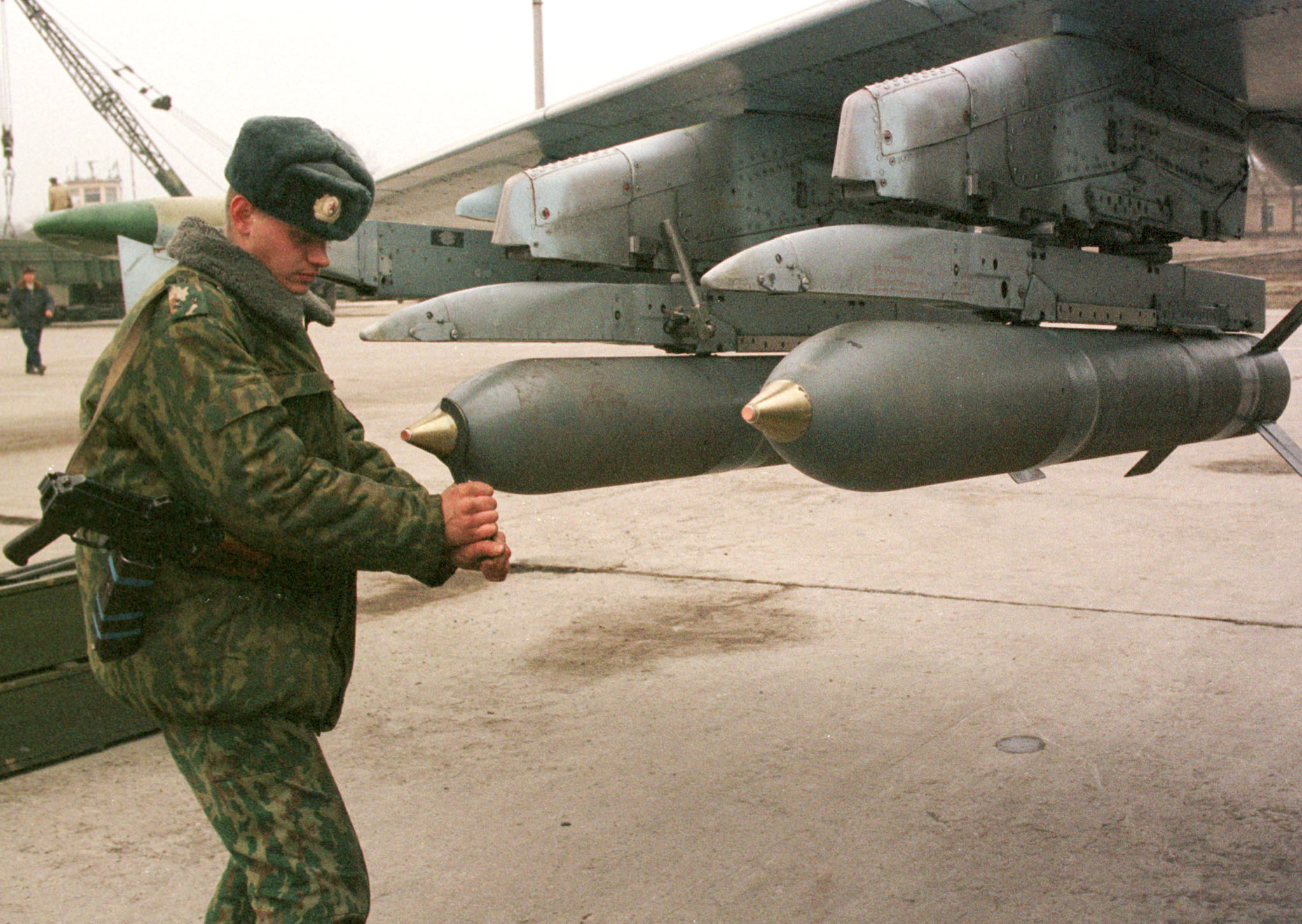Russian ground staff officer fixes detonators on bombs attached to a jet at a military airfield in Mozdok, in Ossetia December 20. Prime Minister Vladimir Putin said December 22 the military campaign in rebel Chechnya was near its end and Interfax news agency said commanders had received orders and were ready to take the capital Grozny. Picture taken December 20. CVI/AA