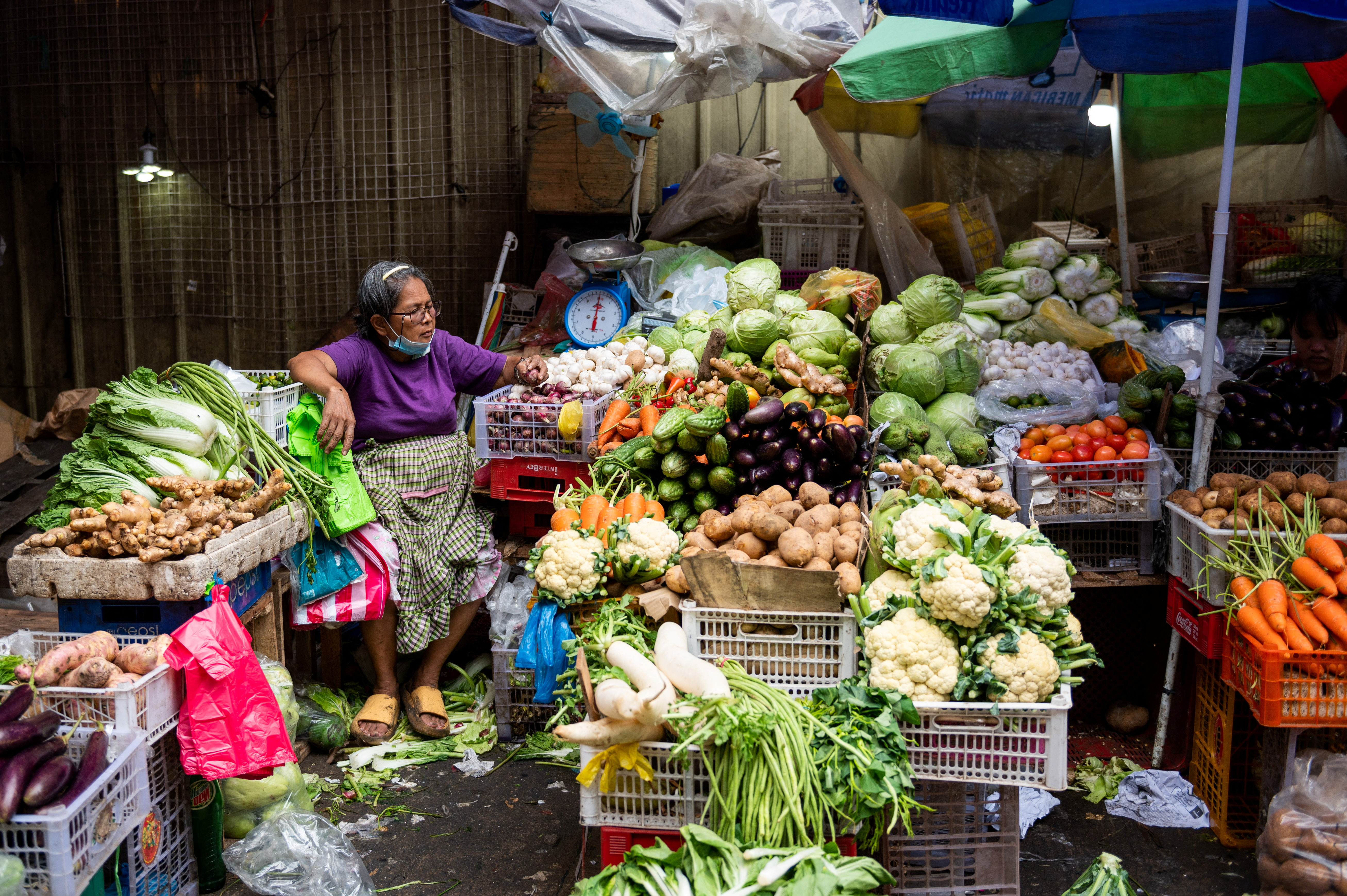 A vegetable vendor tends to her store at a public market, ahead of New Year celebration, in Manila, Philippines, December 30, 2022