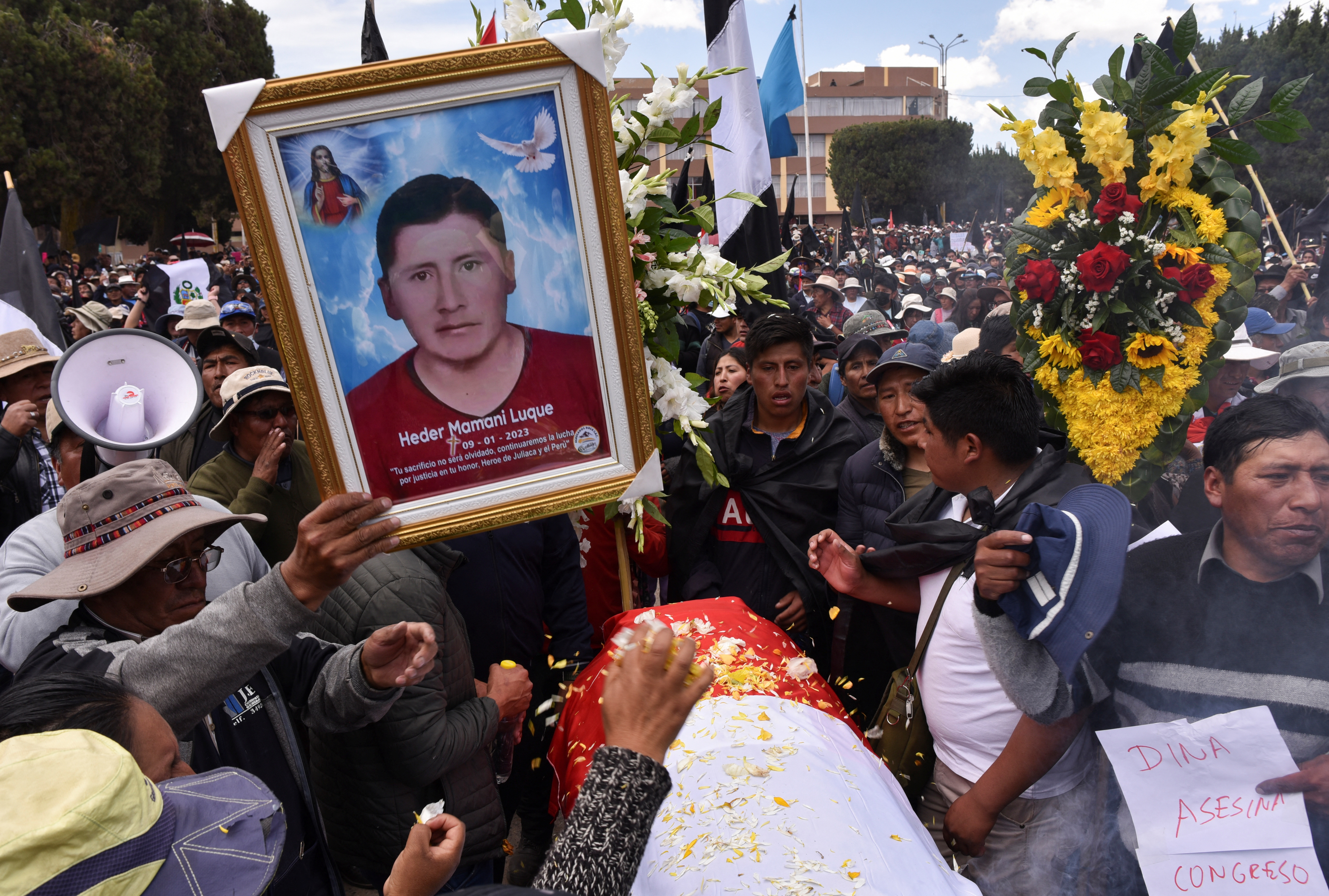 People react near the coffin of a man killed in clashes with Peru security forces