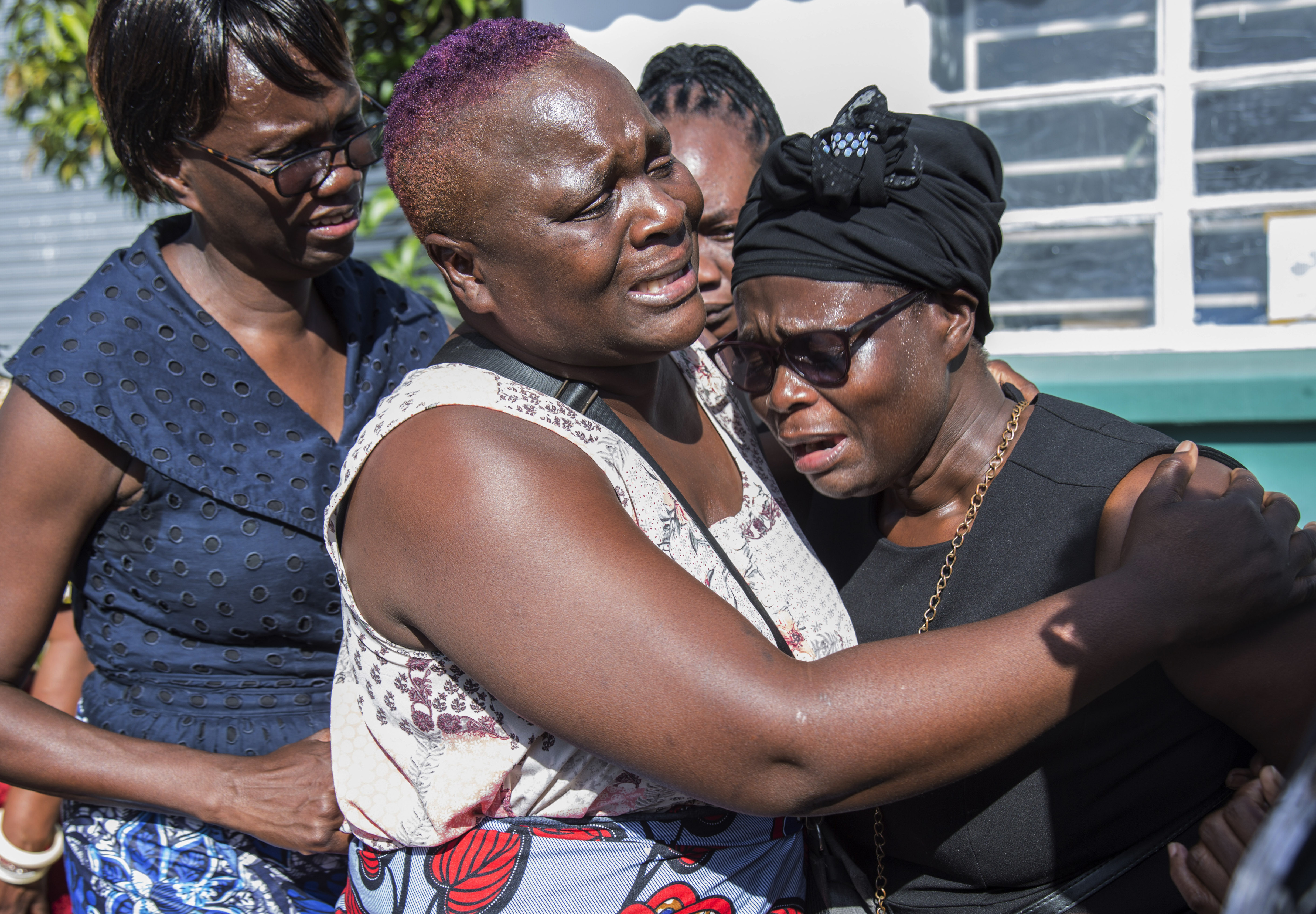 Florence Nyirenda, mother of Lemekhani Nyireda, is comforted by family members at the Kenneth Kaunda International Airport in Lusaka, Zambia, Sunday, Dec. 11 2022. The body of a 23-year-old Zambian student who died while fighting for the Russian army in the war in Ukraine has been returned home. The body of Lemekani Nyirenda who was studying nuclear engineering in Russia before joining the military arrived at Kenneth Kaunda International Airport in Lusaka on Sunday. (AP Photo/Salim Dawood)