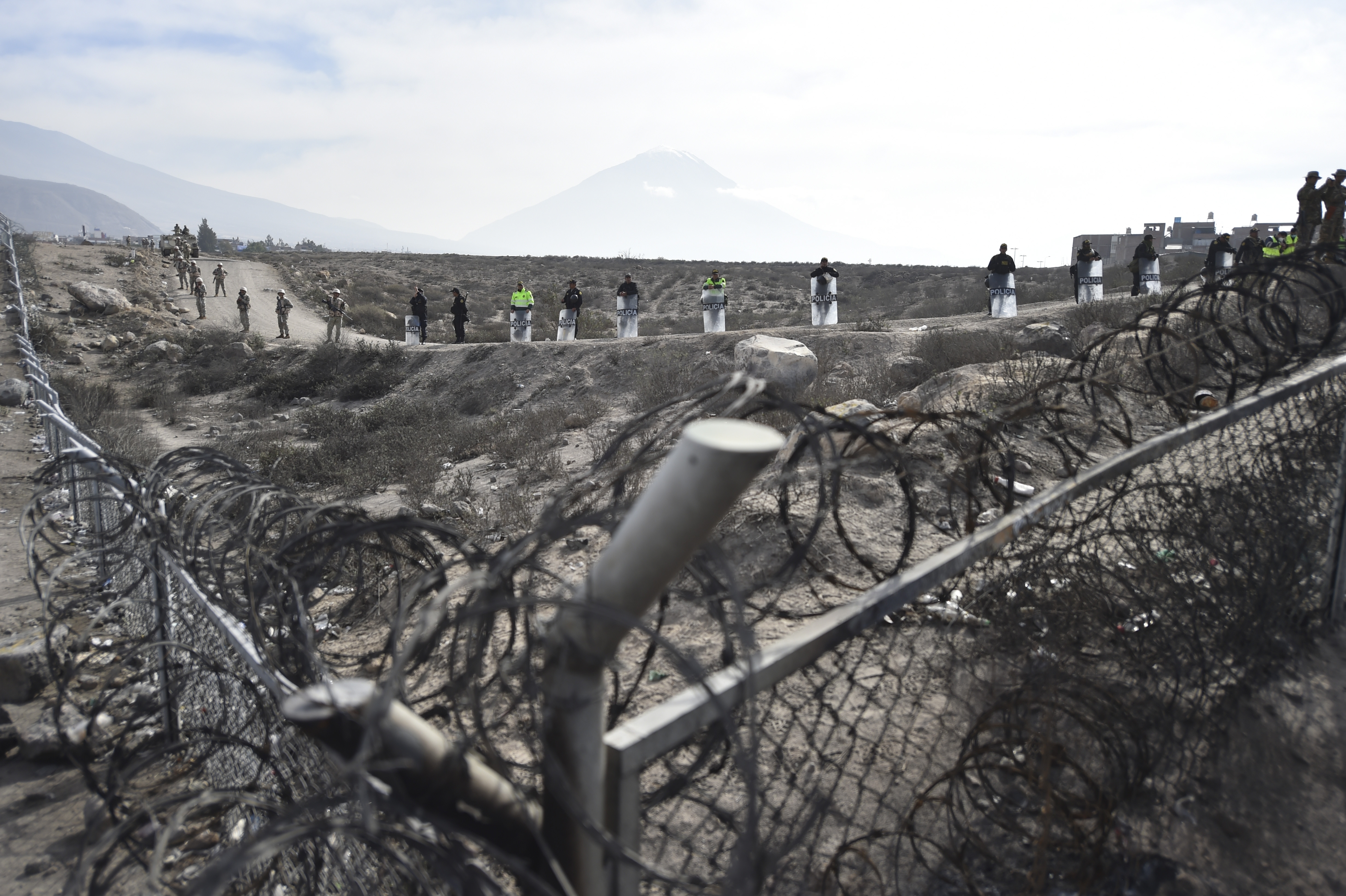 Soldiers and police stand guard at an airport in Peru