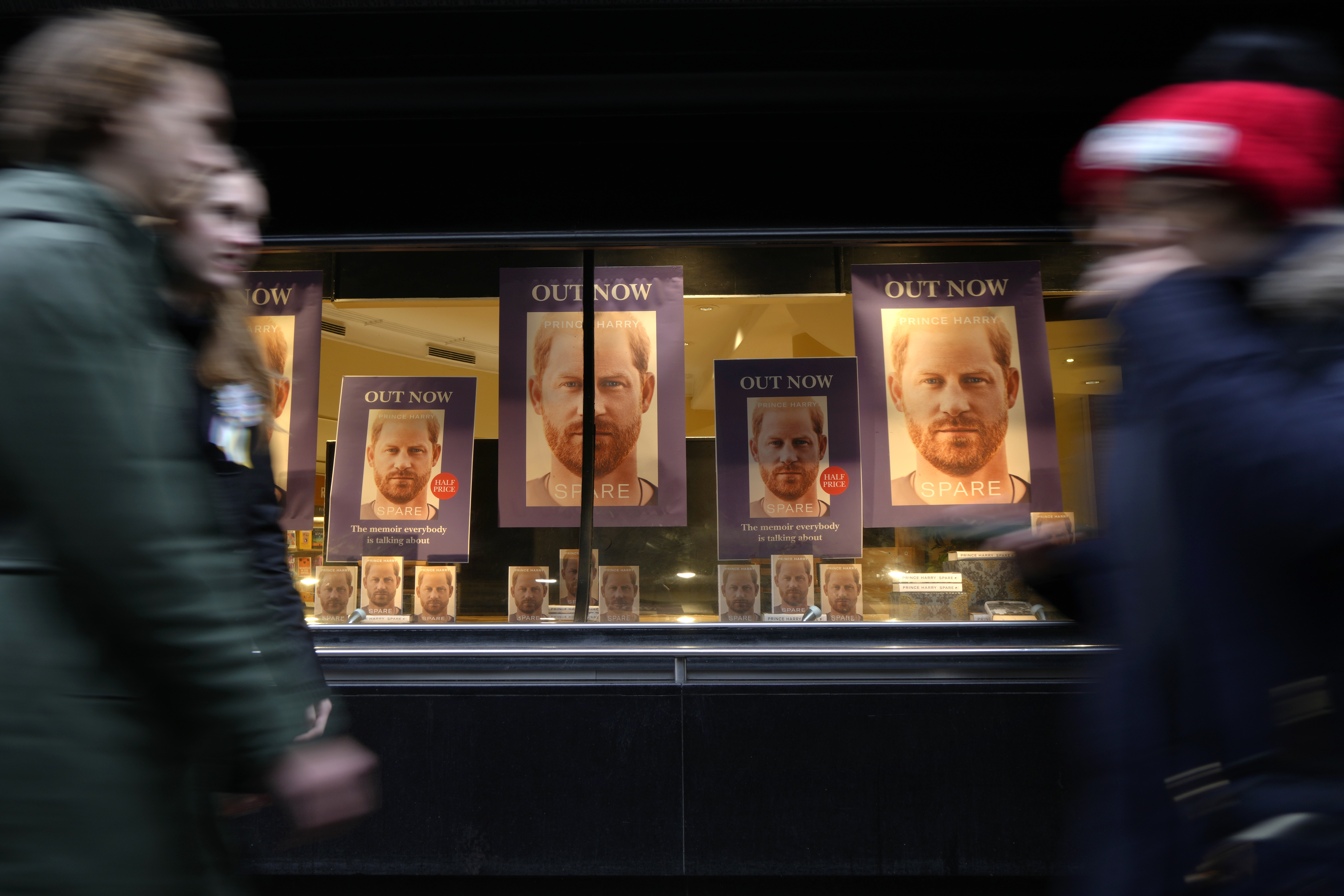 Pedestrians pass a display in the window of a book shop in London, the United Kingdom, where Prince Harry's book is prominently displayed.