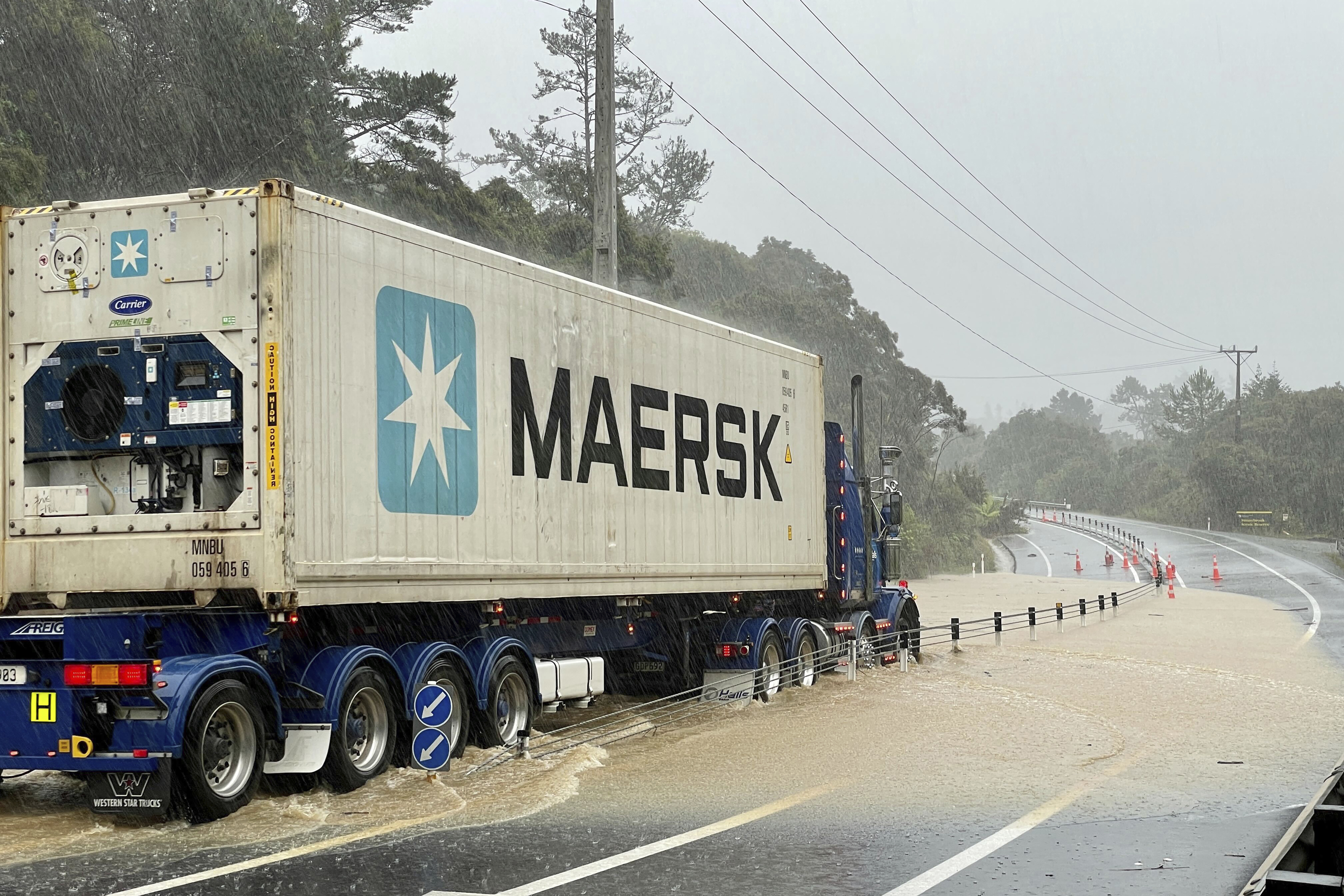 A truck is stopped by flood water near Auckland, New Zealand, Friday, Jan. 27, 2023. Torrential rain and wild weather in Auckland causes disruptions throughout the city and an Elton John concert to be canceled just before it was due to start.
