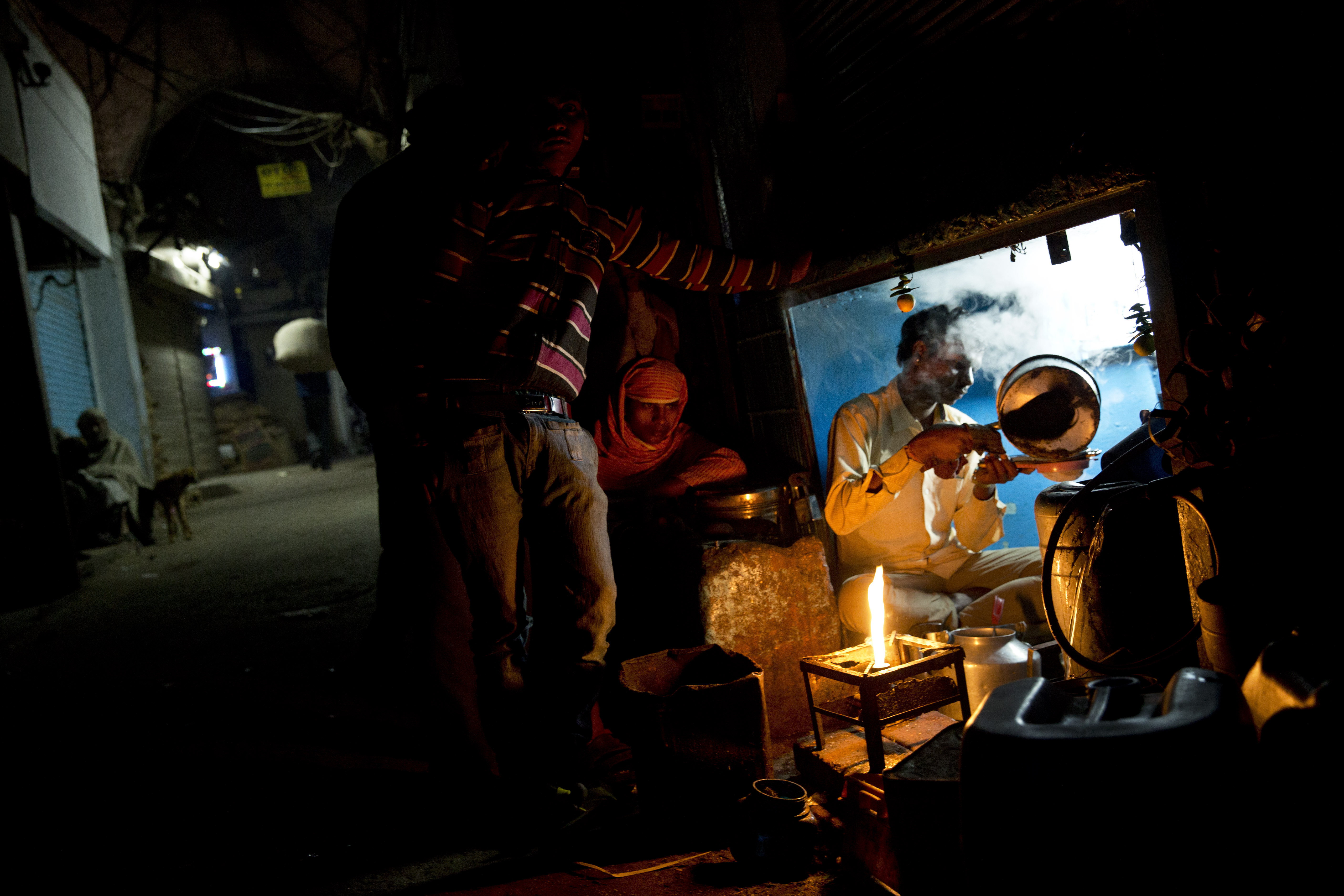 A tea seller prepares tea for laborers in the old city area of New Delhi, India