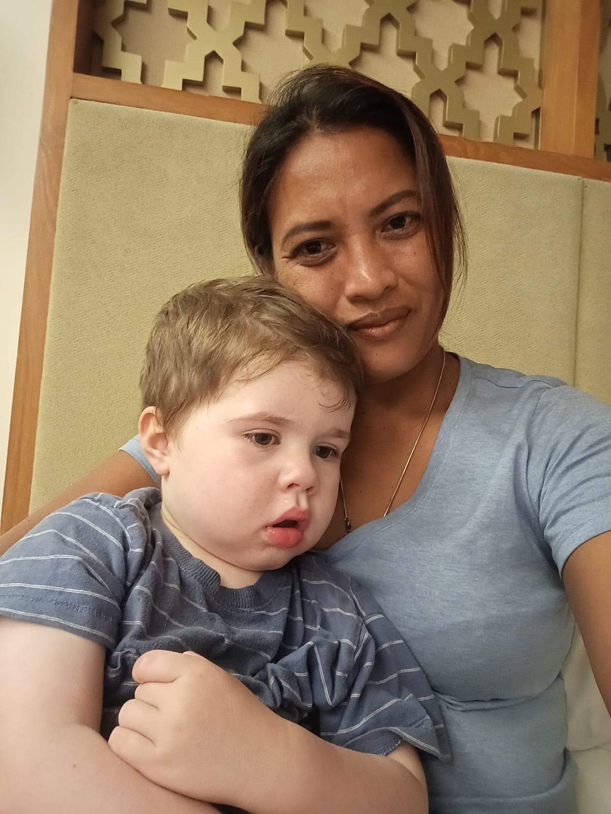 Ni Luh Putu Rustini holding a child on her lap.