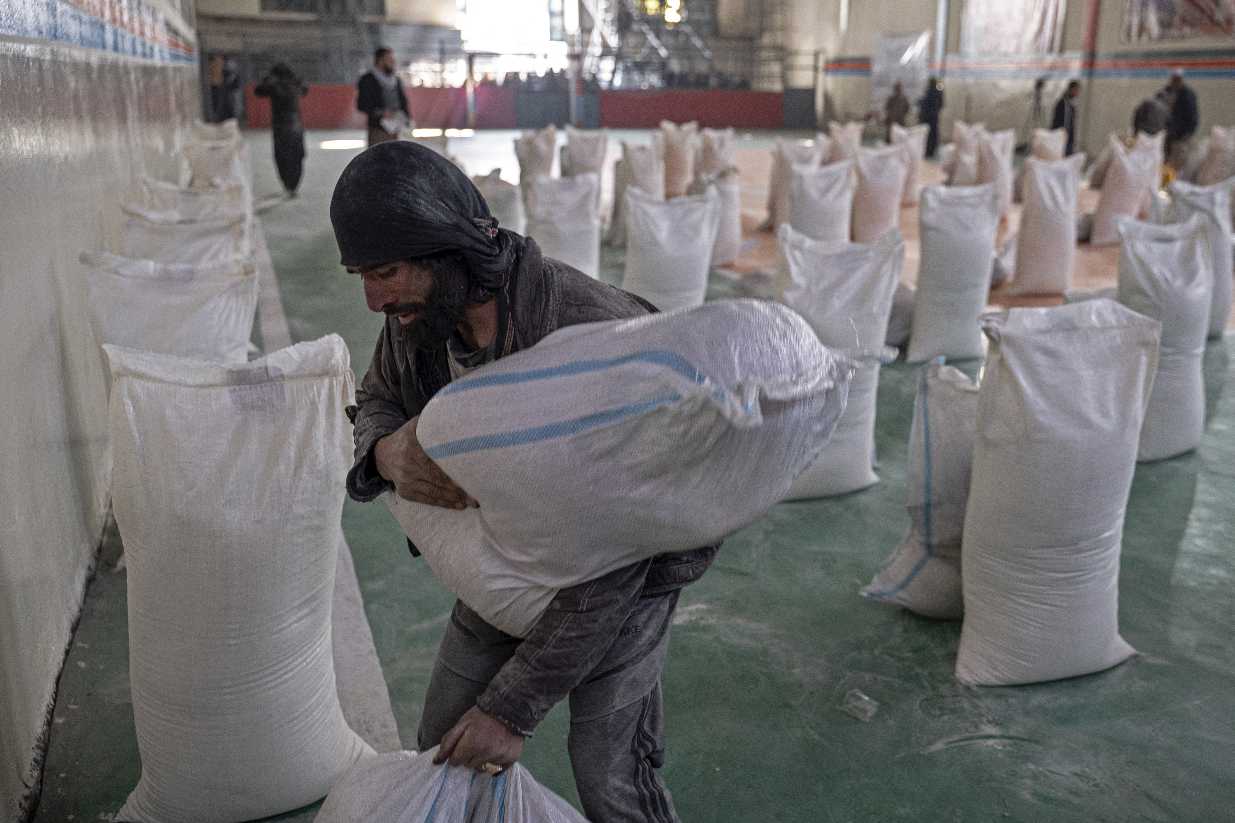 A man arranges food aid bags at a gymnasium in Kabul.