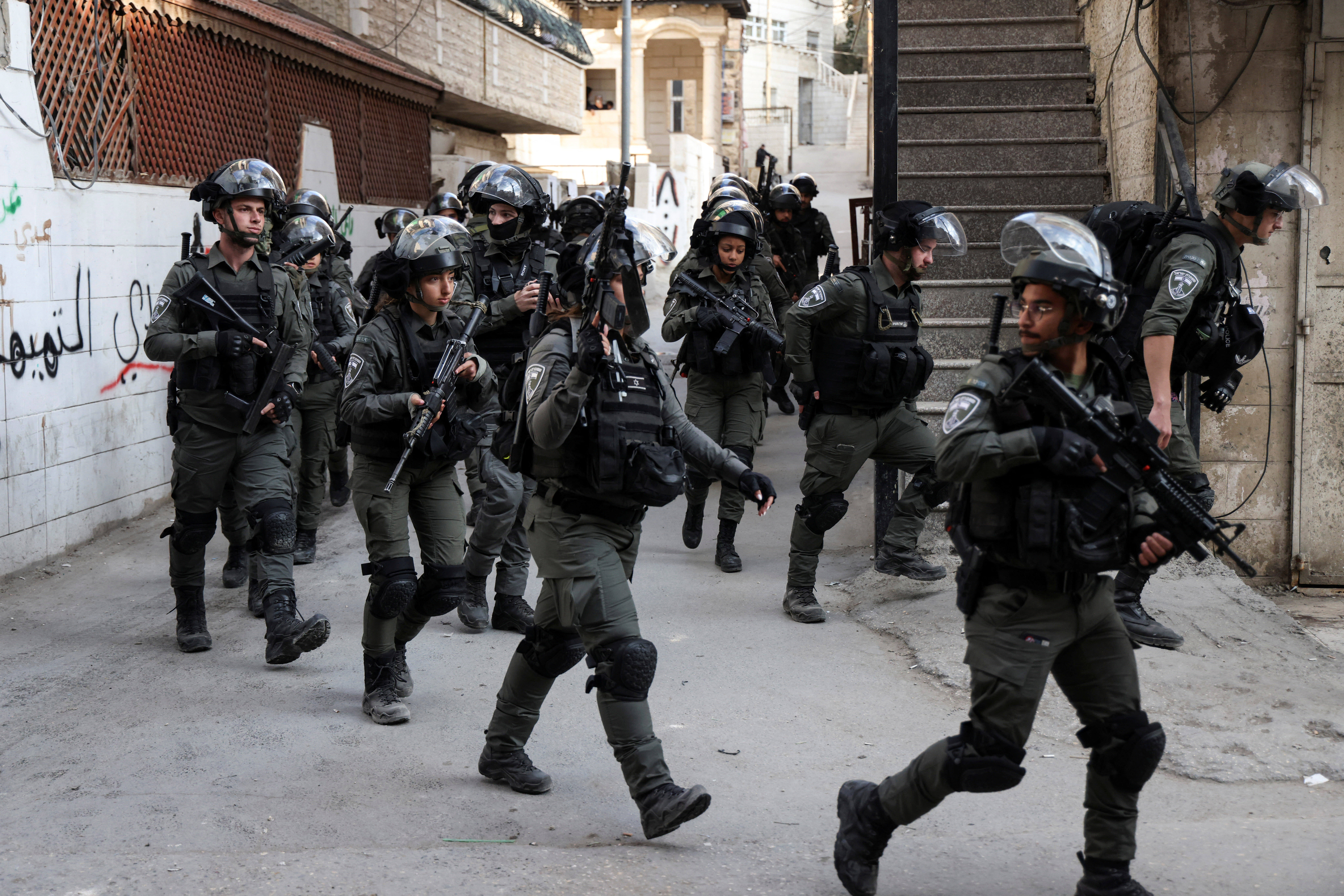 Israeli forces advance during clashes after Israeli forces destroy and seal off the family apartment of Uday Al-Tamimi