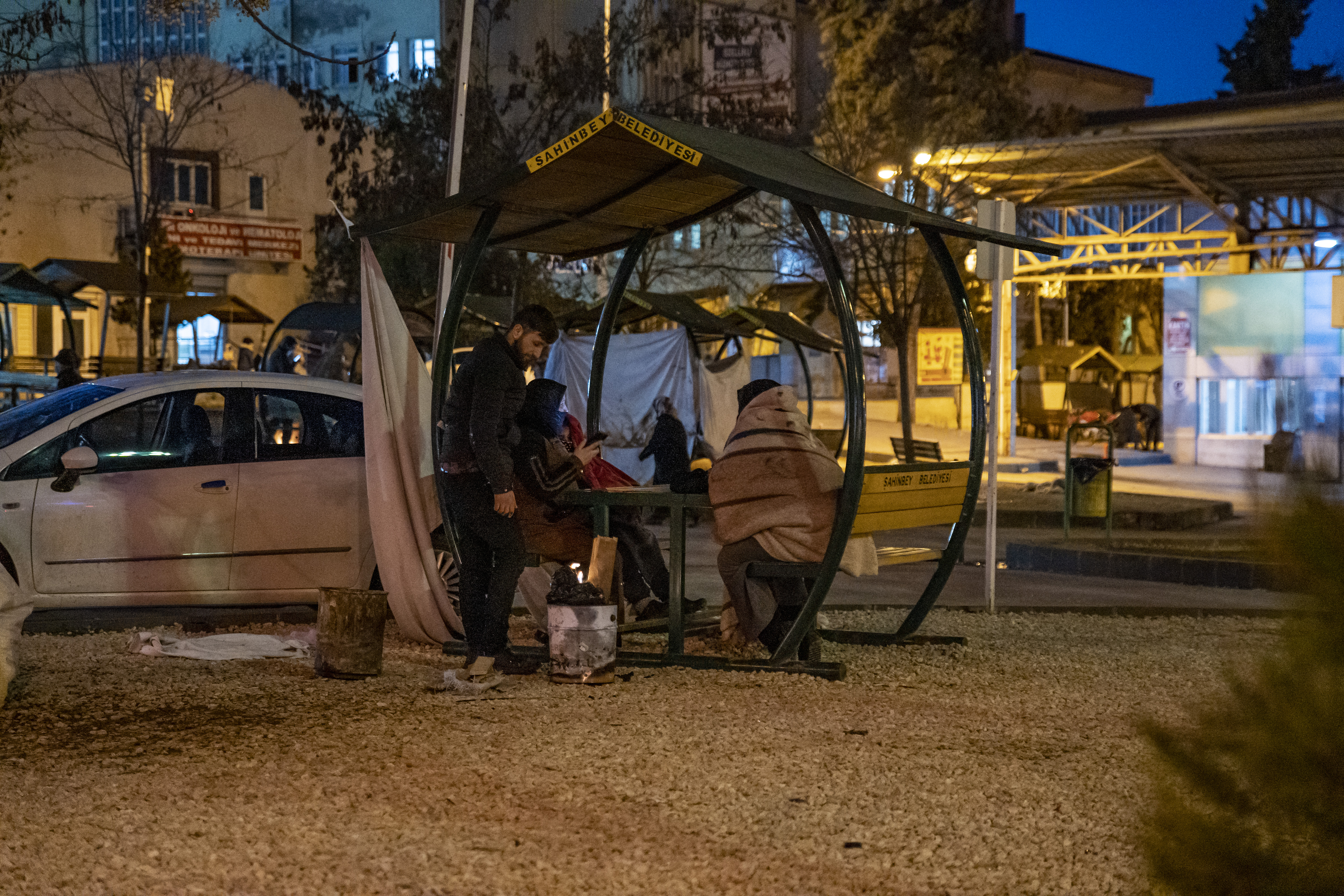 A family uses a public park bench to sleep for the night in front of Ersin Arslan Hospital in Gaziantep 