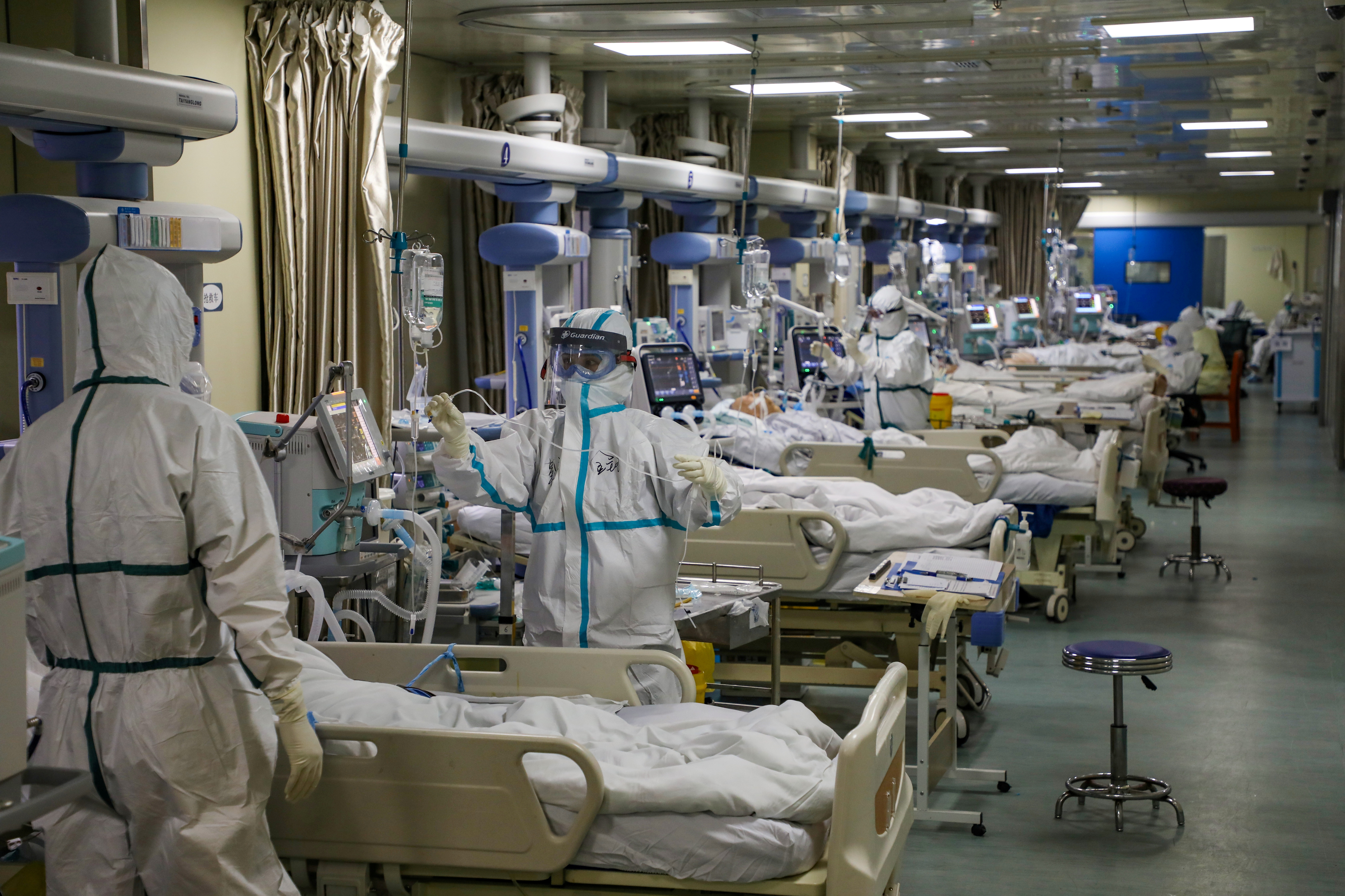 Medical workers in protective suits attend to novel coronavirus (COVID) patients at the intensive care unit (ICU) of a designated hospital in Wuhan, Hubei province, China