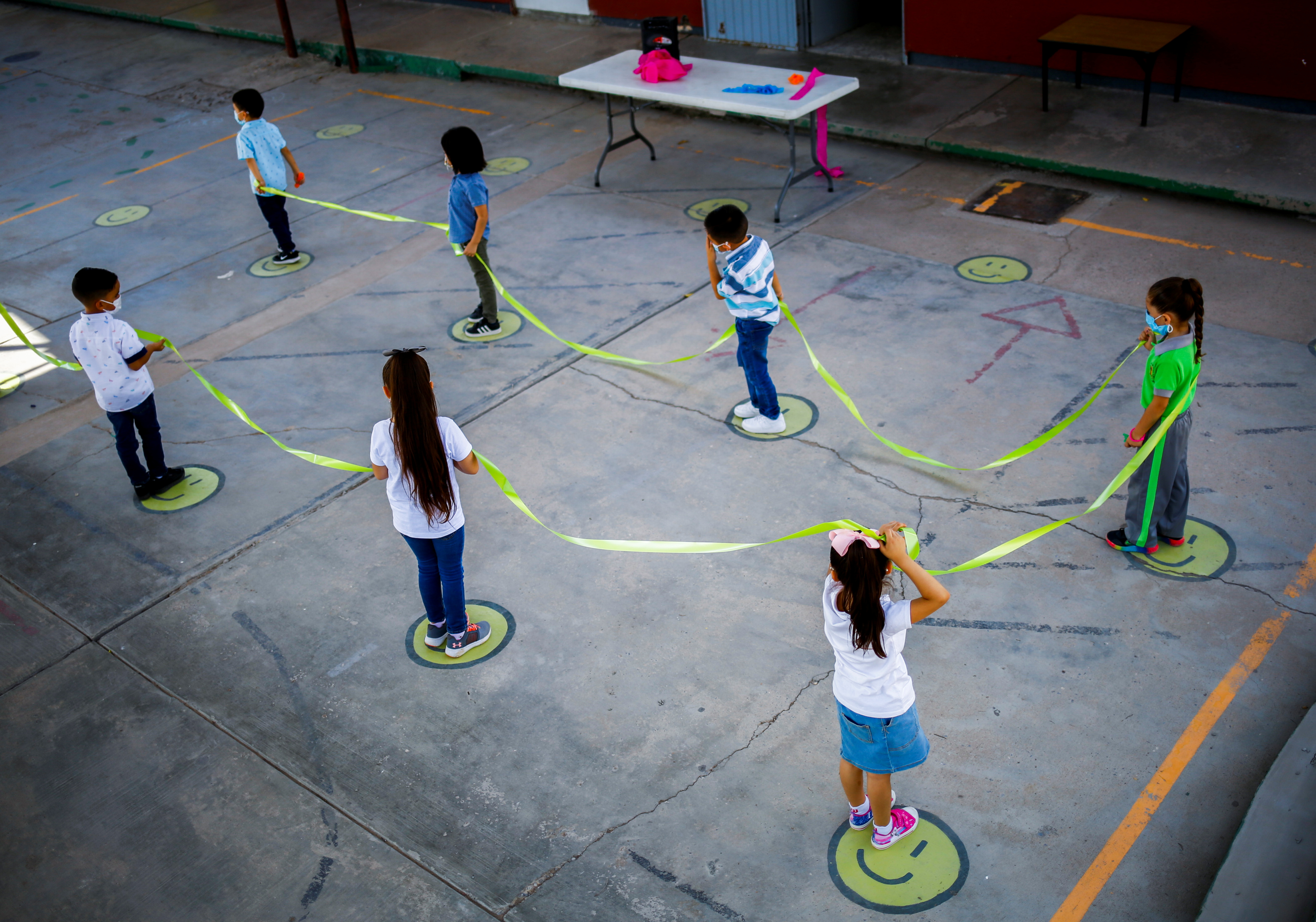 Children hold a cord to maintain social distance in a kindergarten, as in-person classes return after over a year of online lessons as the coronavirus disease (COVID-19) outbreak continues, in Ciudad Juarez, Mexico August 30, 2021. REUTERS/Jose Luis Gonzalez