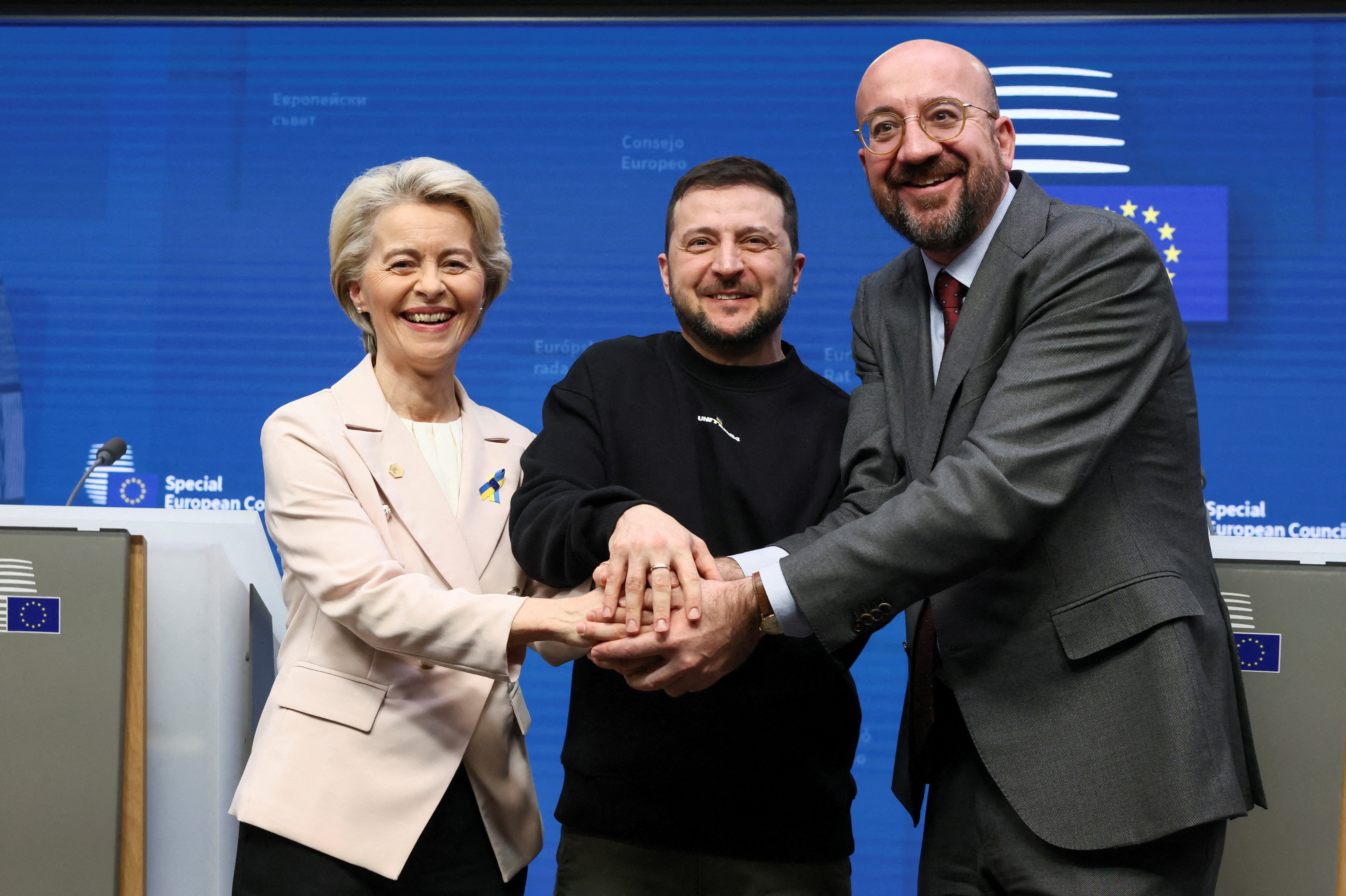 European Commission President Ursula von der Leyen, Ukrainian President Volodymyr Zelenskiy and European Council President Charles Michel shake hands in Brussels.