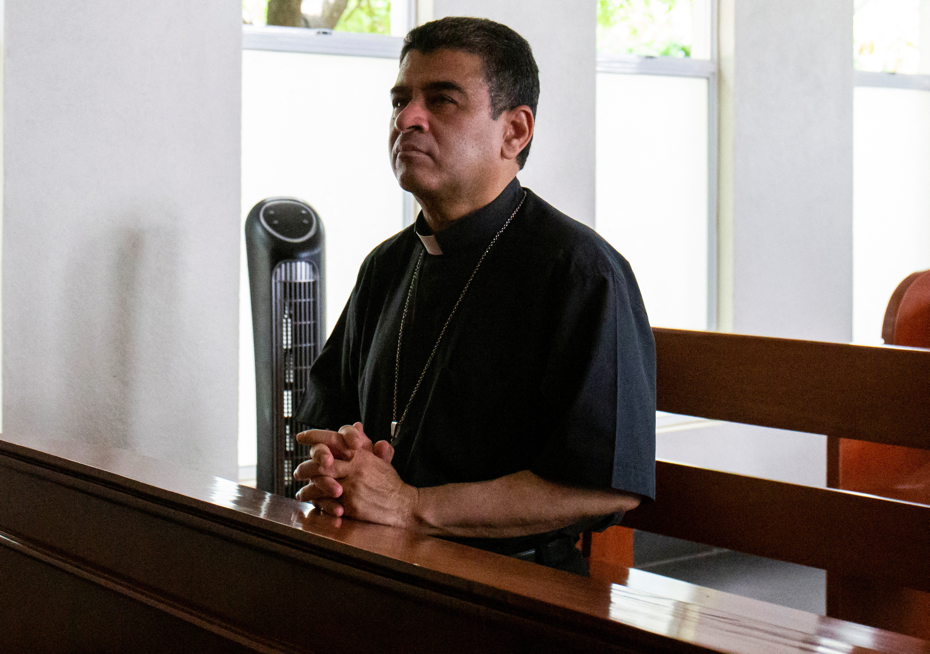 Bishop Rolando Alvarez praying in a pew.