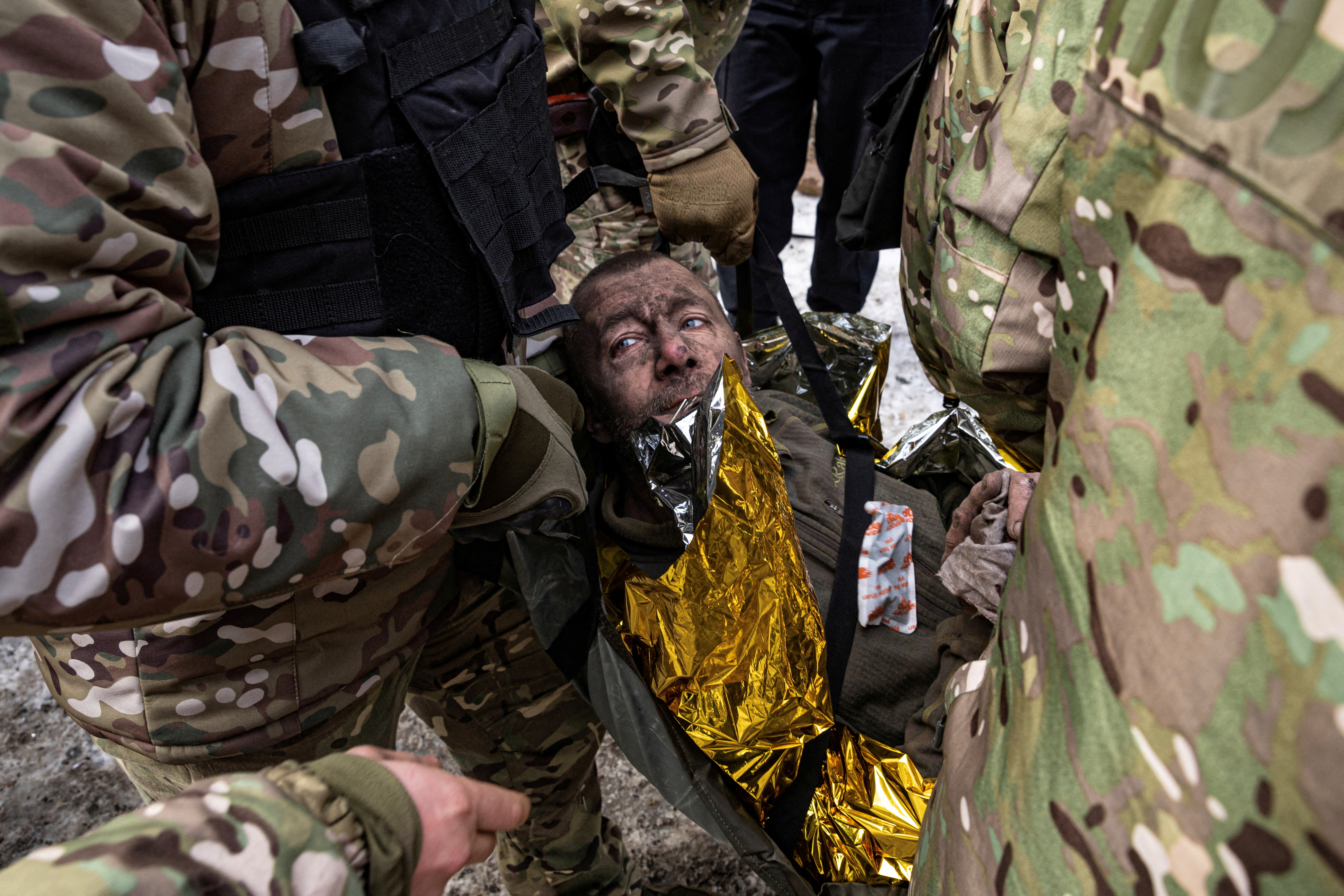 A man is rescued by firefighters after an apartment block was heavily damaged by a missile strike, amid Russia's attack on Ukraine, in Pokrovsk, Donetsk region, Ukraine, February 15, 2023. REUTERS/Marko Djurica TPX IMAGES OF THE DAY