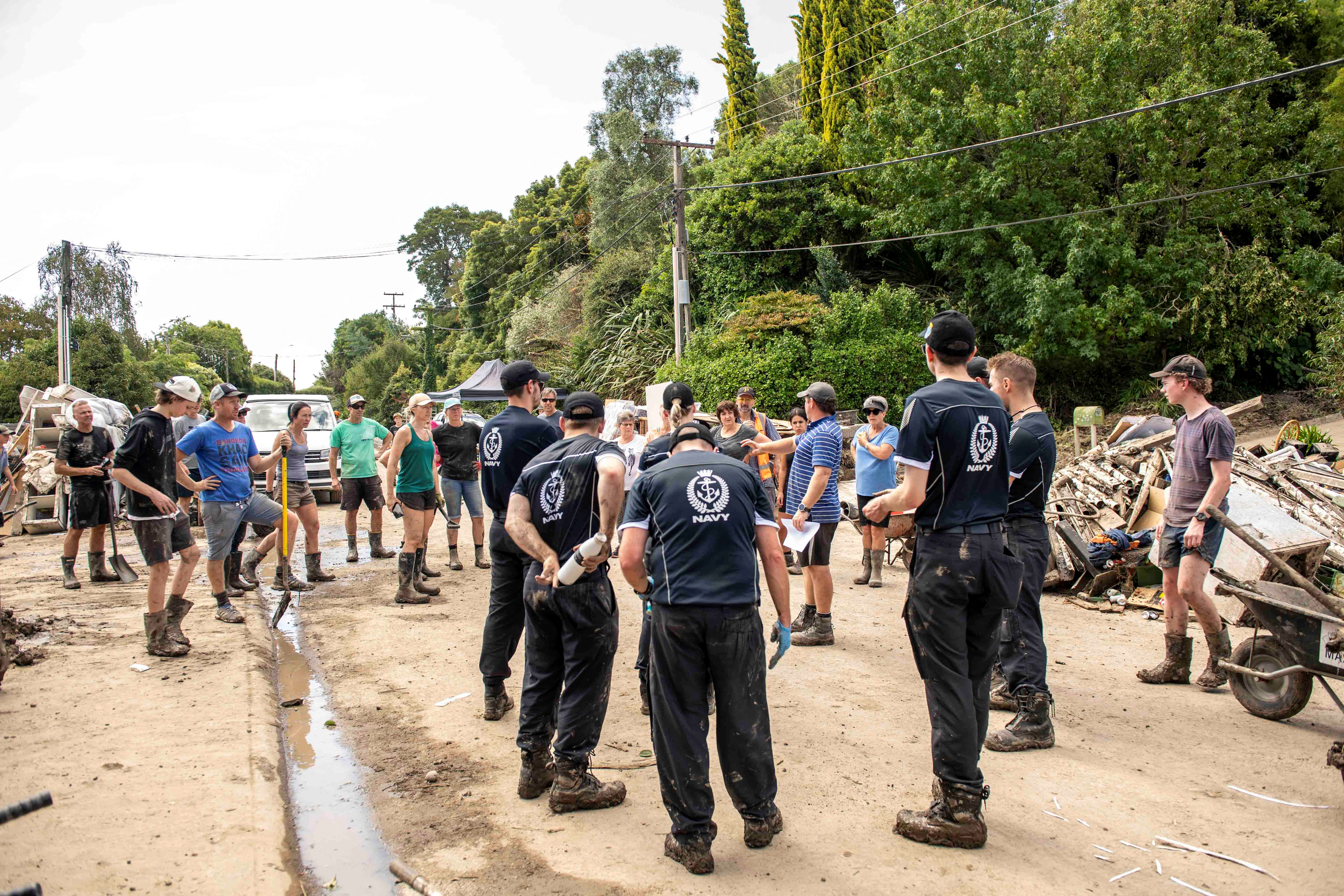 Emergency workers help with a clean up after a small creek bursts its bank causing houses to flood in Havelock North, New Zealand