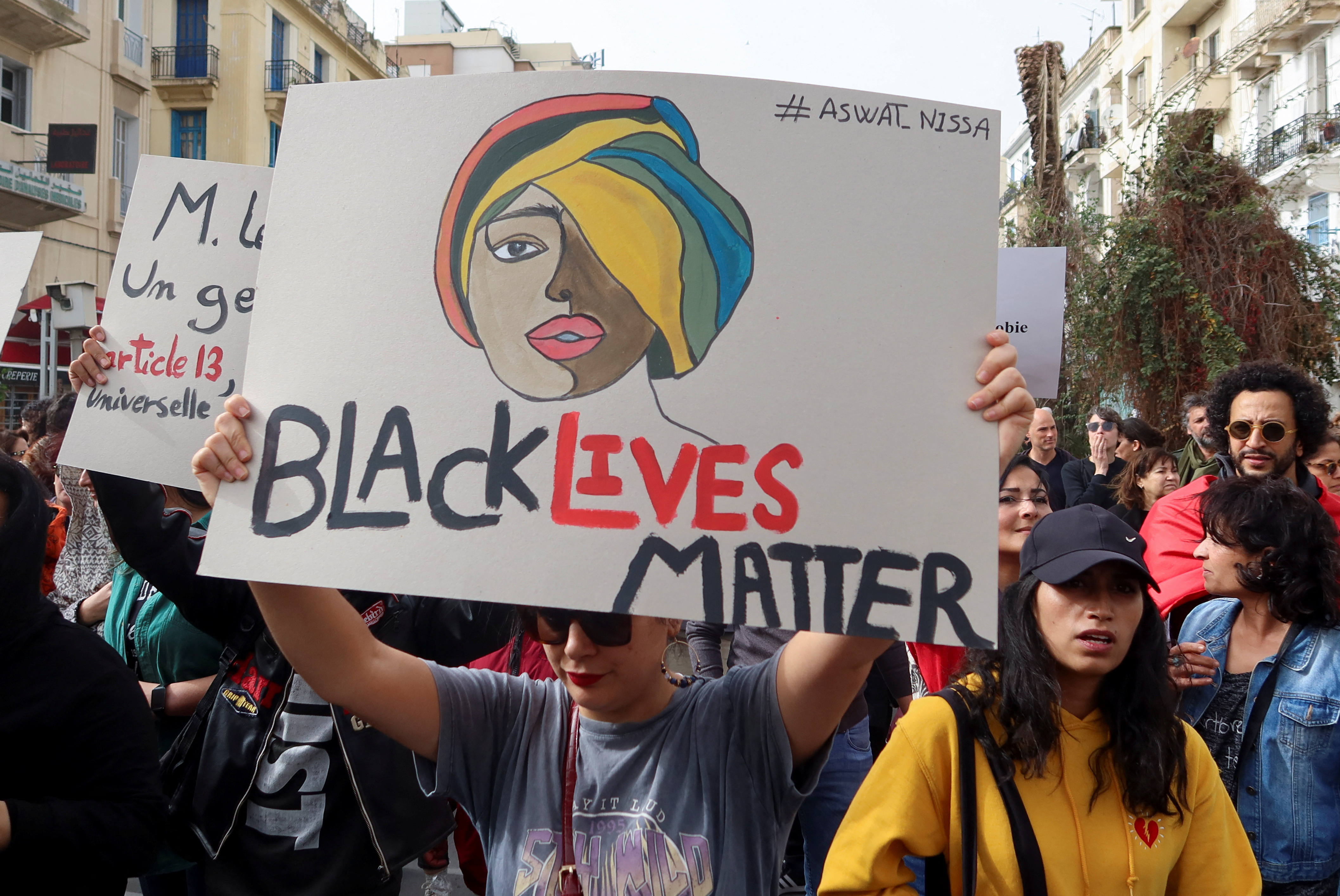 Members of rights groups carry banners during a protest, after Tunisian President Kais Saied ordered security forces to stop all illegal migration and expel all undocumented migrants, in Tunis, Tunisia