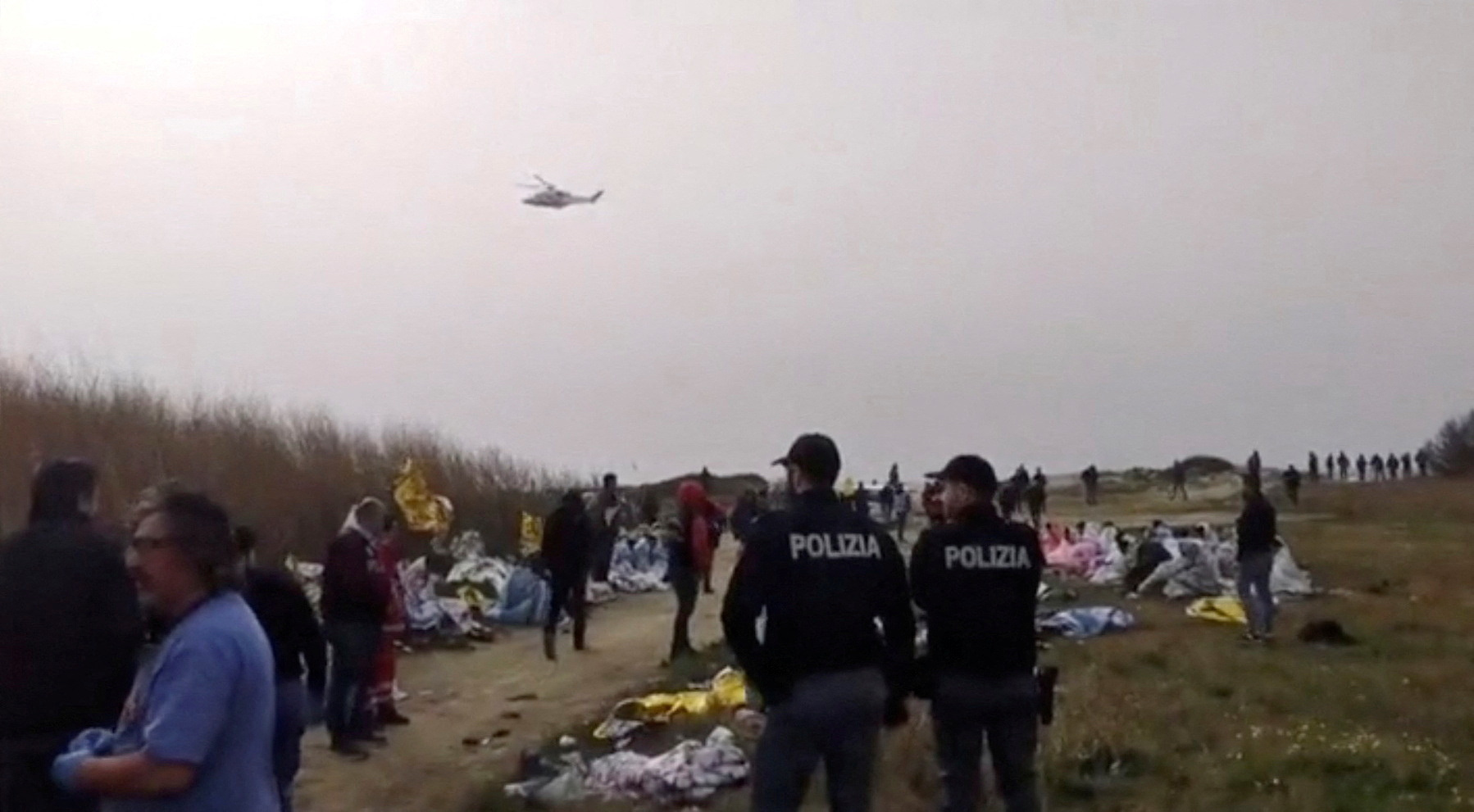 A screengrab from a video shows police officers on the beach where bodies believed to be those of refugees were found after a shipwreck