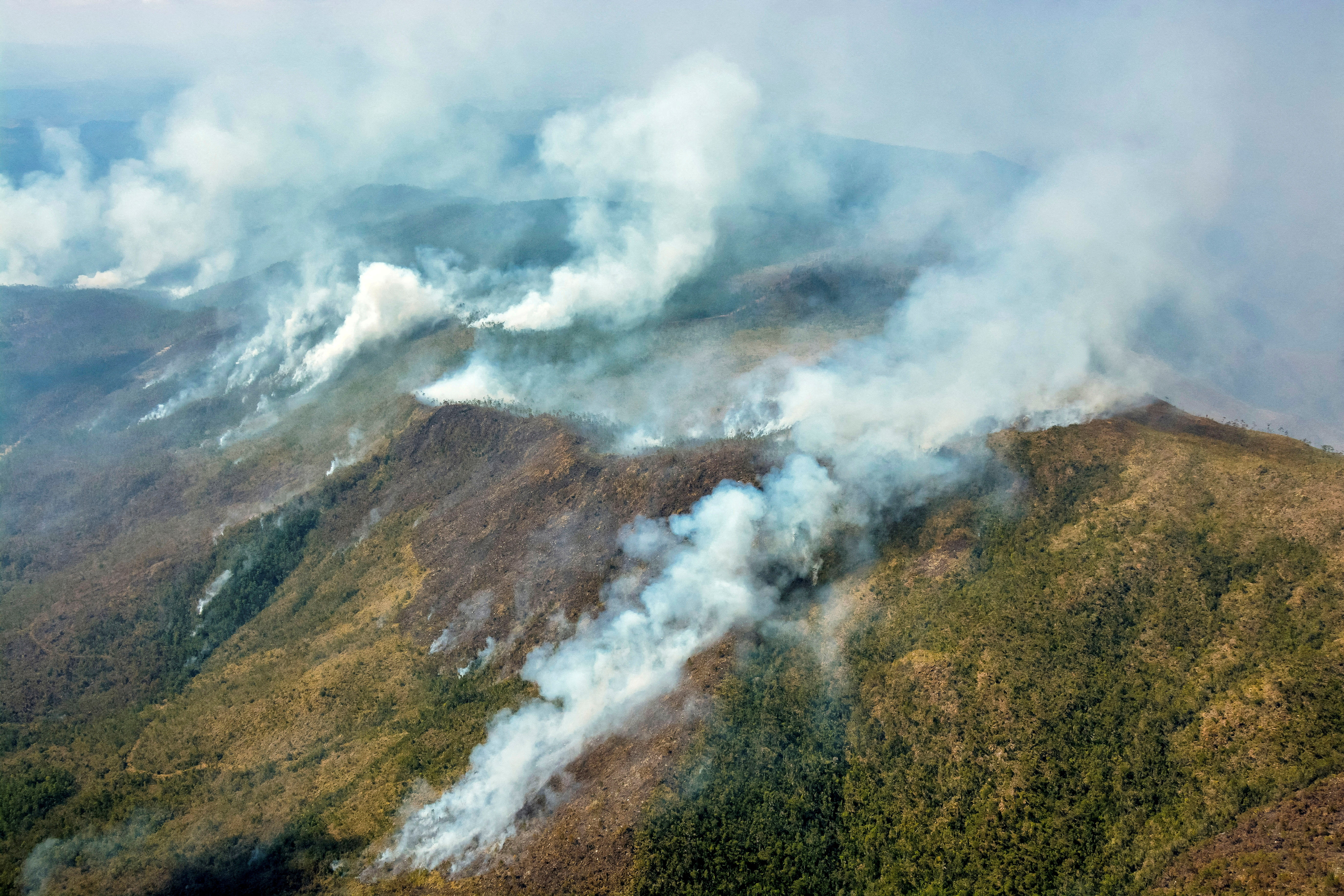 A mountainous region of Cuba emits plumes of smoke as forest fires tear across the area