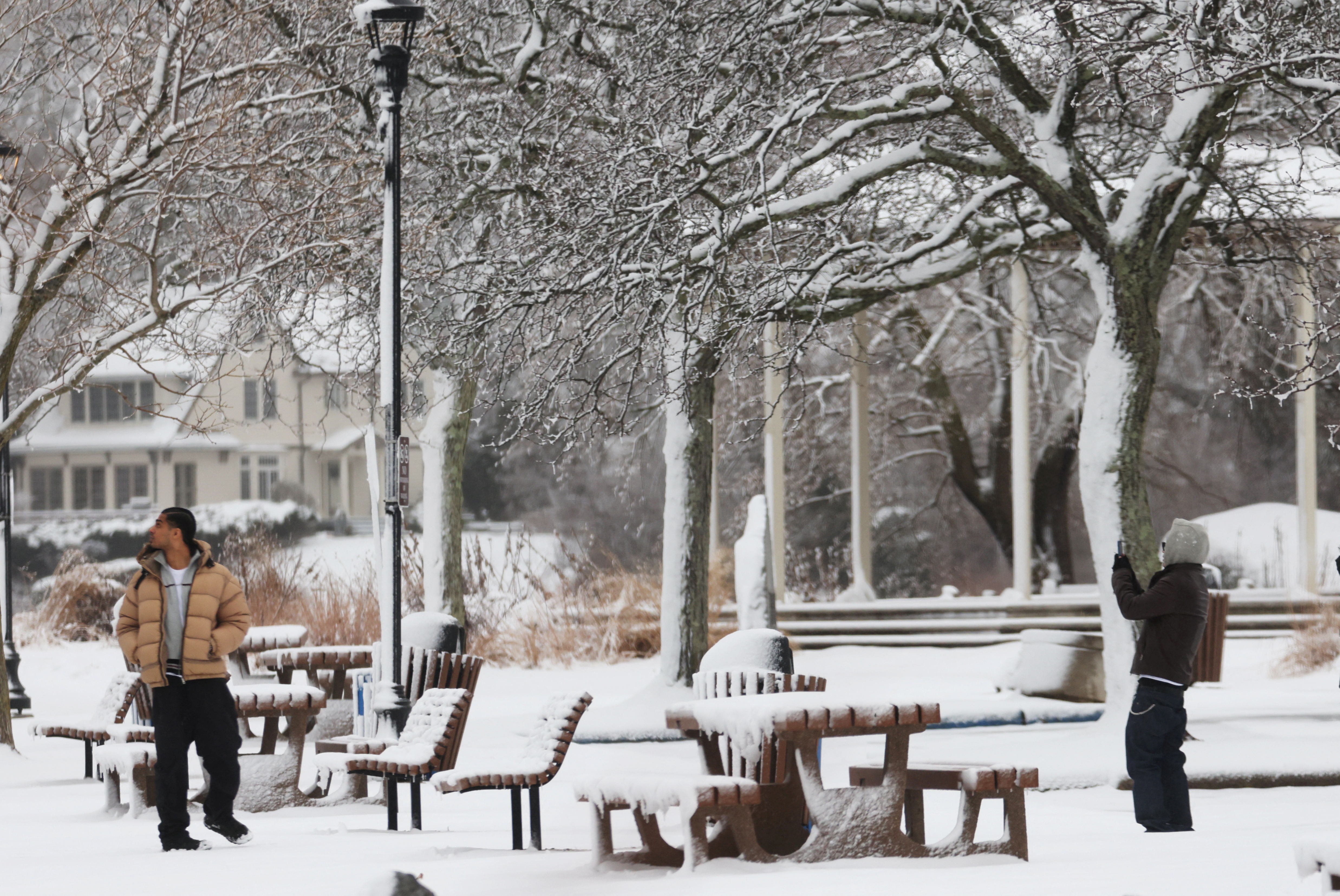 People take pictures in Memorial Park on the Hudson River waterfront during a winter storm in the New York City