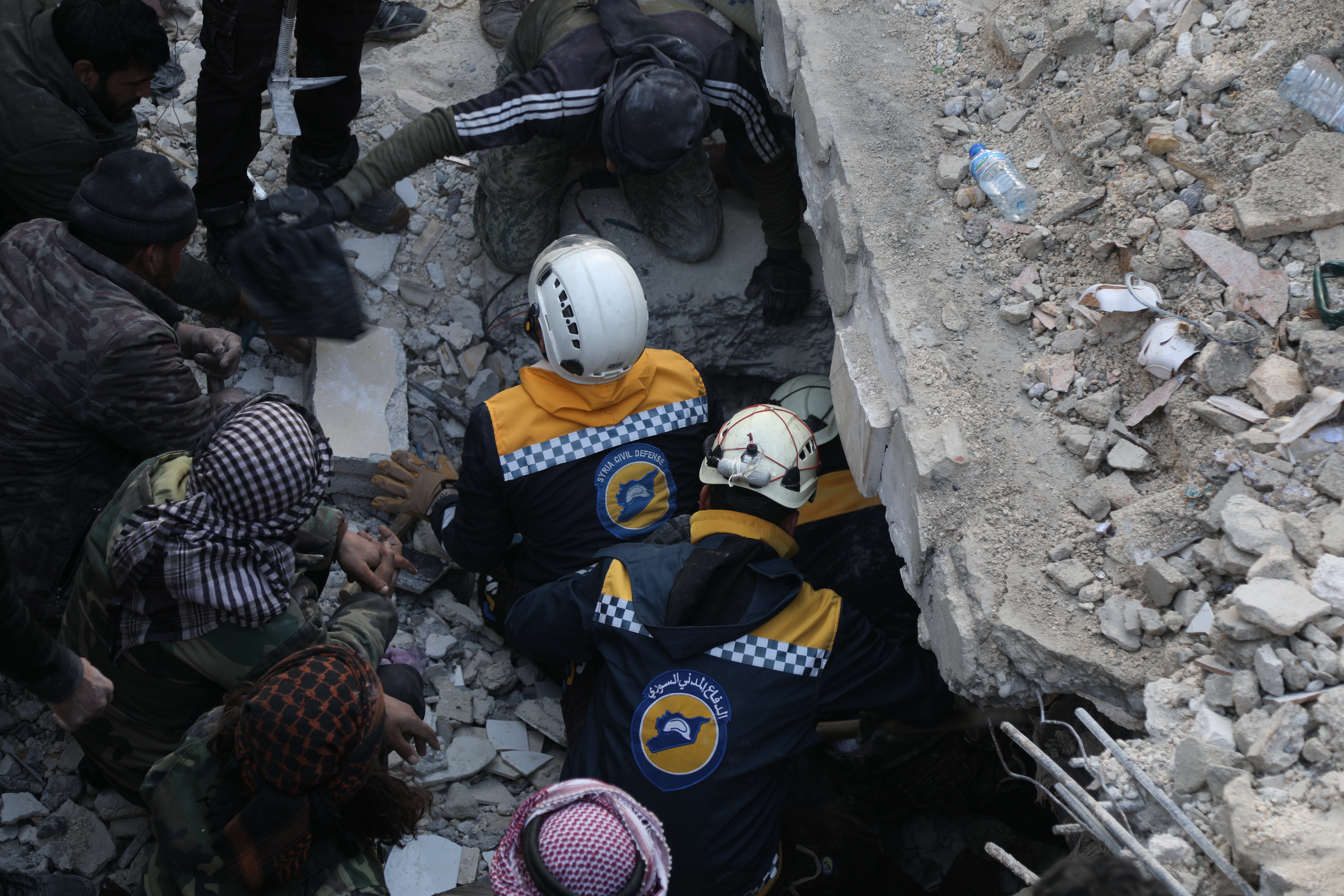 Two members of the White Helmets civil defence team search for survivors under destroyed buildings 