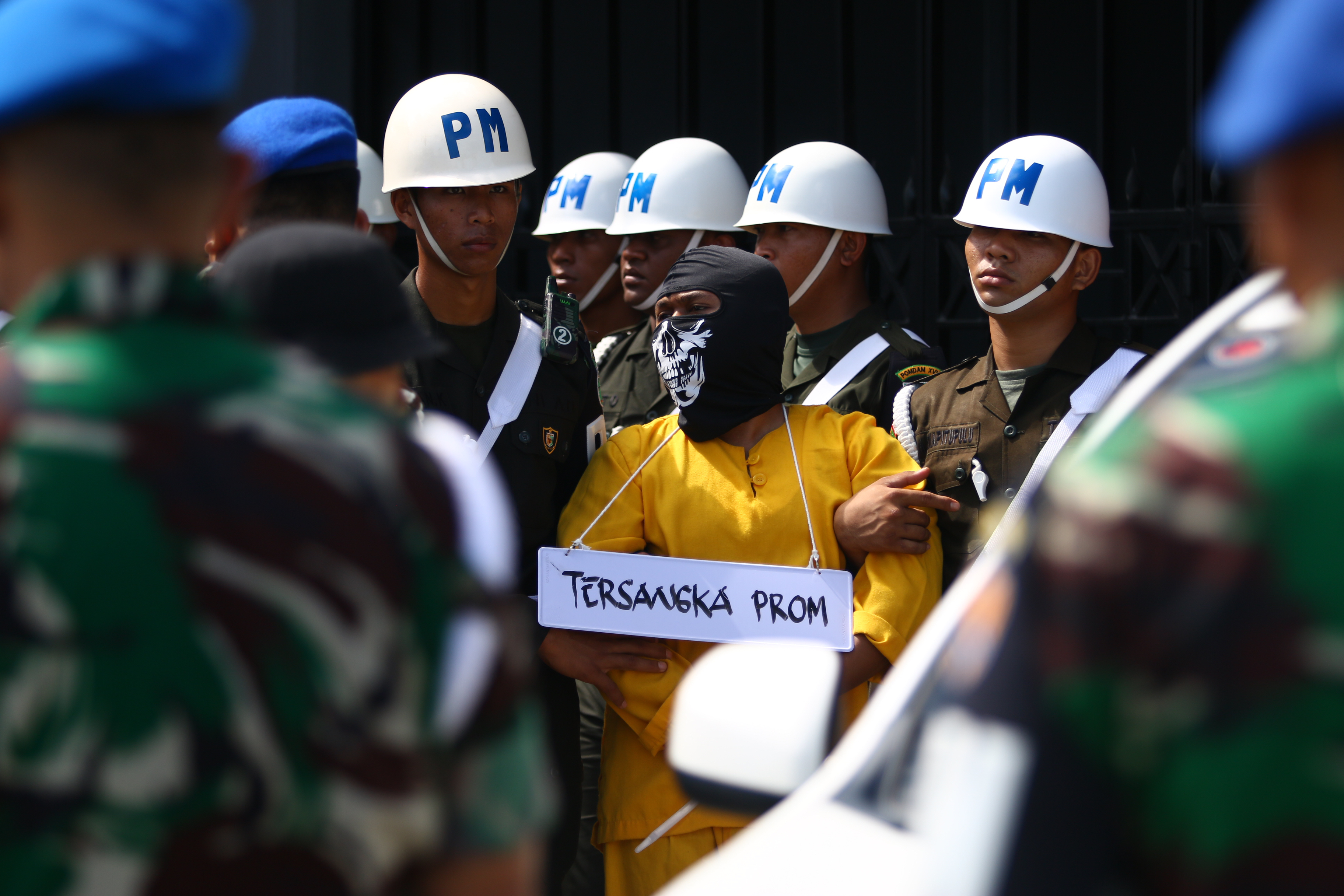 Military police escort a suspect for a crime reconstruction in Mimika on September 3, 2022, after he and five other Indonesian soldiers have been accused of killing four indigenous Papuans and mutilating their bodies last week. (Photo by SEVIANTO PAKIDING / AFP)