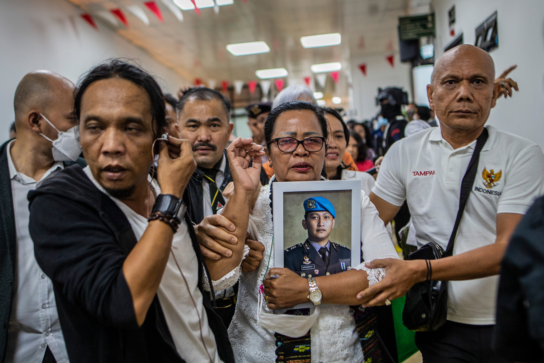 Yosua's mother surrounded by media and supporters outside the court after sentence was passed. She is carrying a picture of her son.