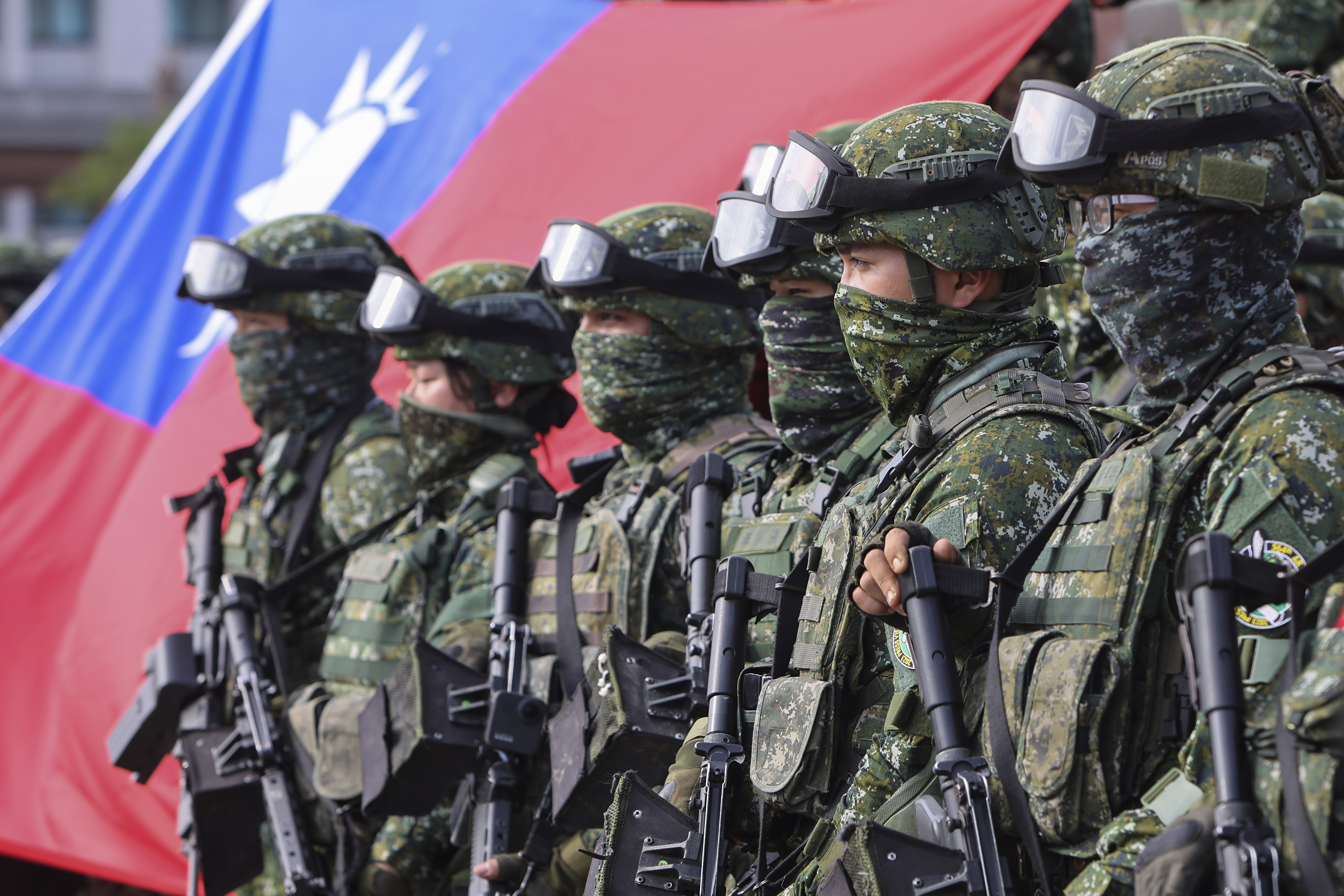 Soldiers pose for group photos with a Taiwan flag after a preparedness enhancement drill simulating the defense against Beijing's military intrusions, ahead of the Lunar New Year in Kaohsiung City, Taiwan on Wednesday, Jan 11, 2023. China renewed its threats Wednesday to attack Taiwan and warned that foreign politicians who interact with the self-governing island are "playing with fire." (AP Photo/Daniel Ceng)