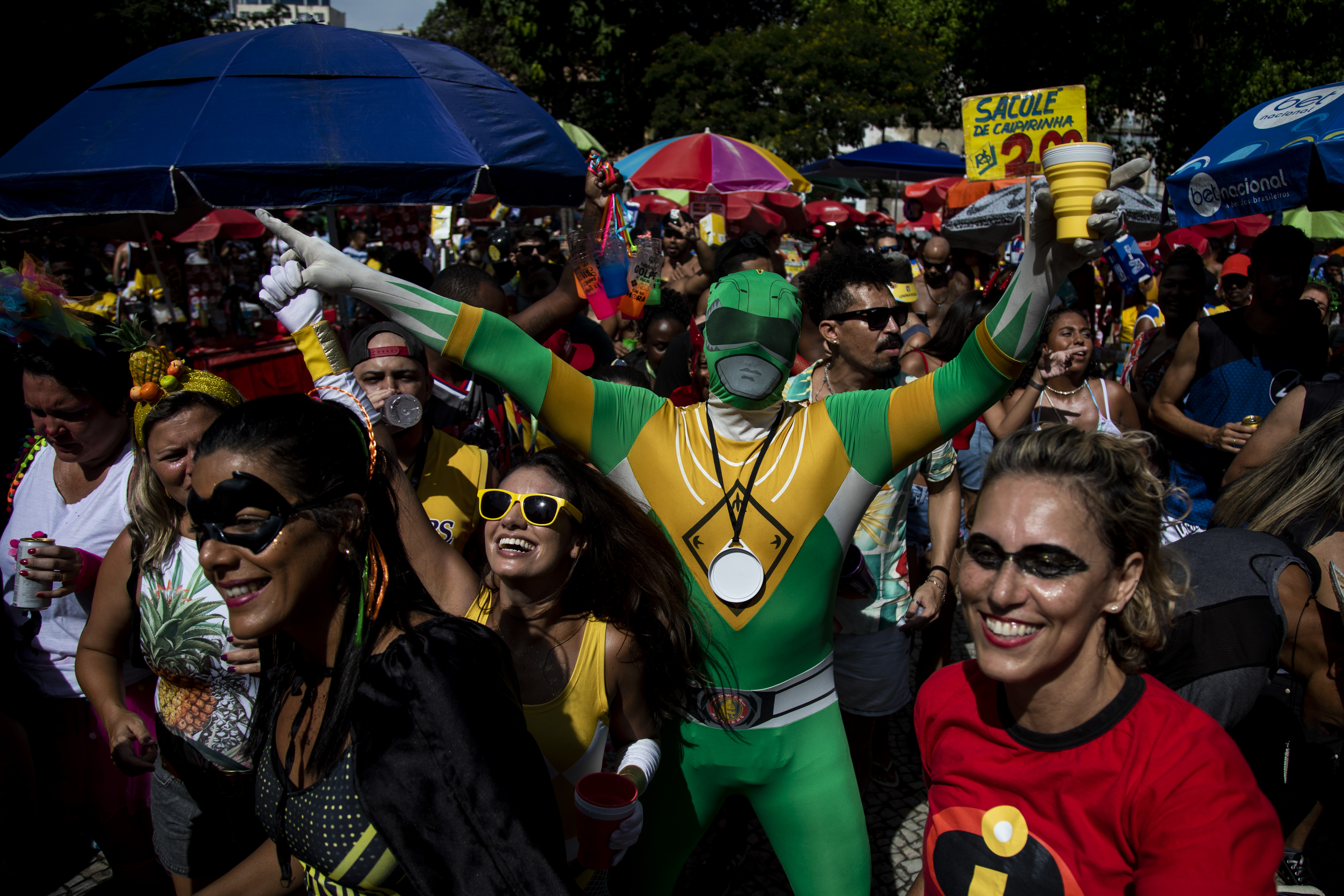 Man dressed as green Power Ranger extends his arms above a crowd