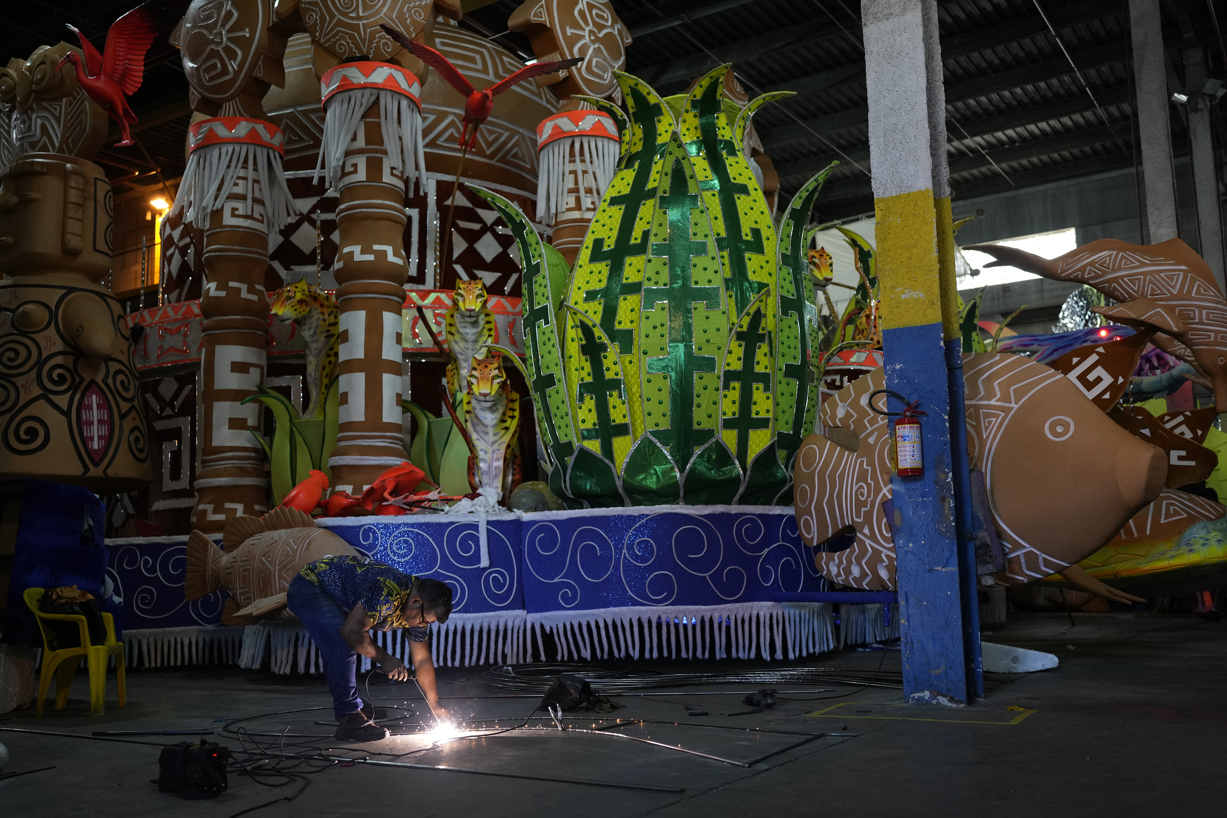 A man welds metal in front of a party float