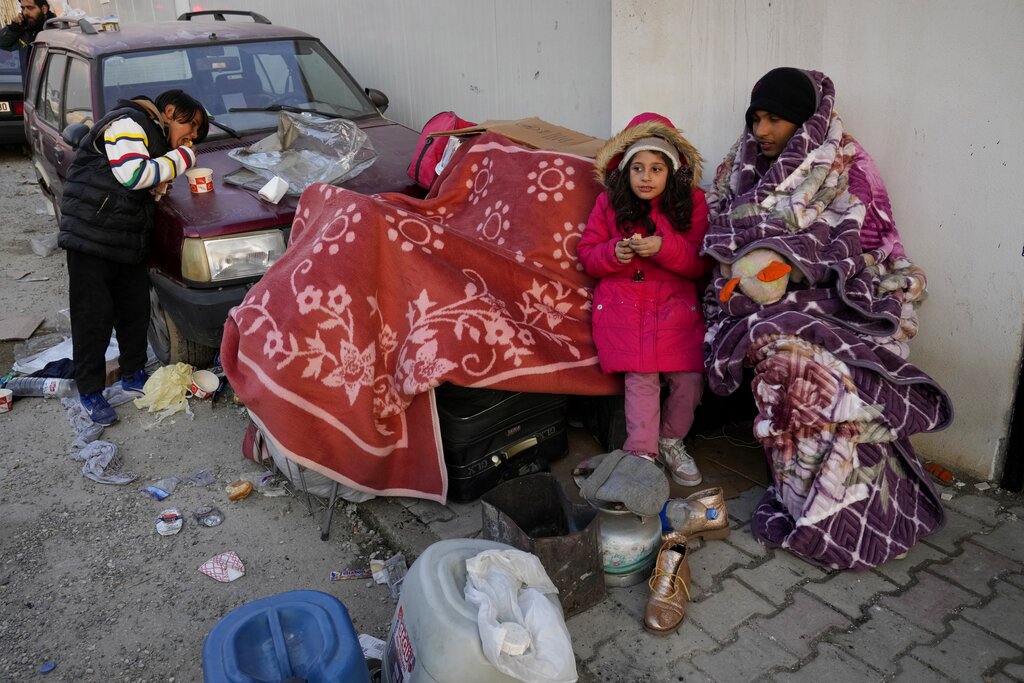 Syrians gather at a shelter in Antakya, southeastern Turkey, Friday, Feb. 10, 2023. The shelter, operated by Molham, a team of Syrian volunteers, was set up soon after the earthquake struck. It has offered temporary shelter, hot meals, and transportation out of the devastated city to hundreds of the thousands of Syrian refugees who fled years ago after war broke out in their hometown and now find themselves once again displaced and homeless. (AP Photo/Hussein Malla)