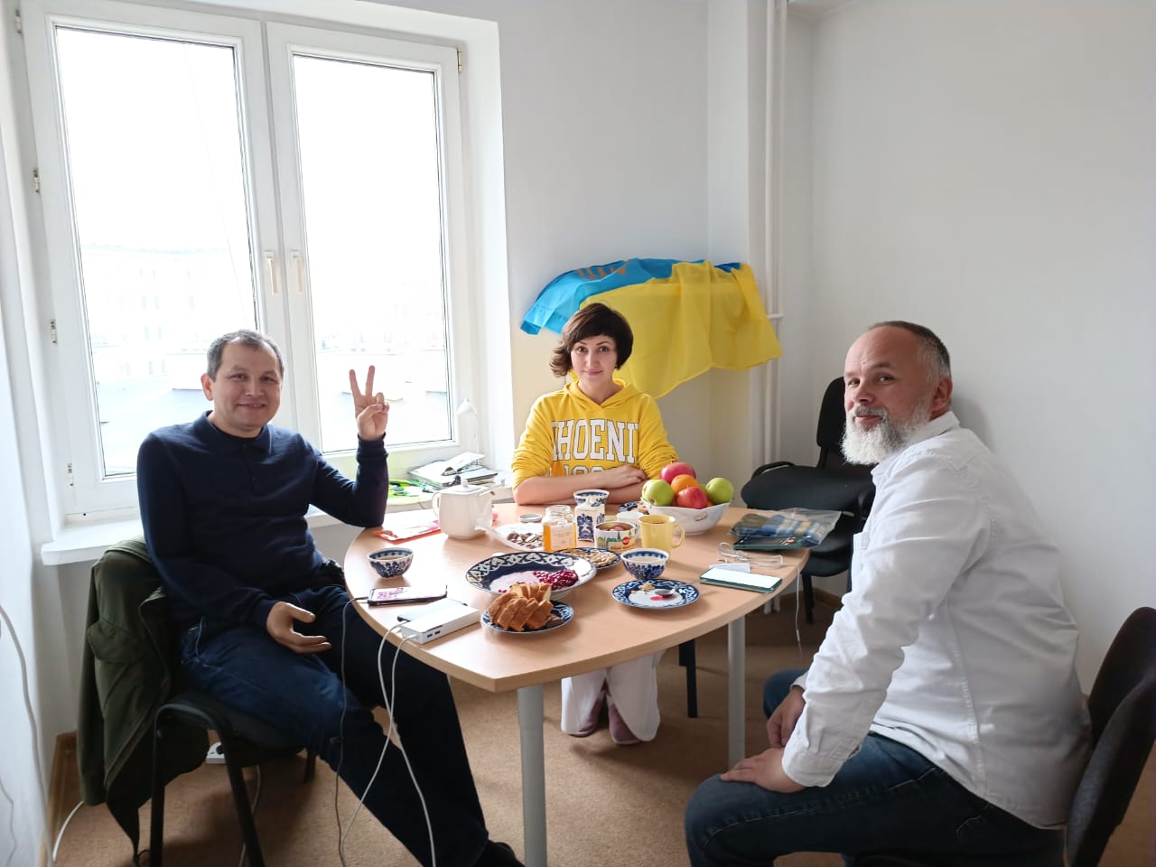 A photo of Zakhida (centre) with her brother Erfan (left) and a friend sitting on a table.