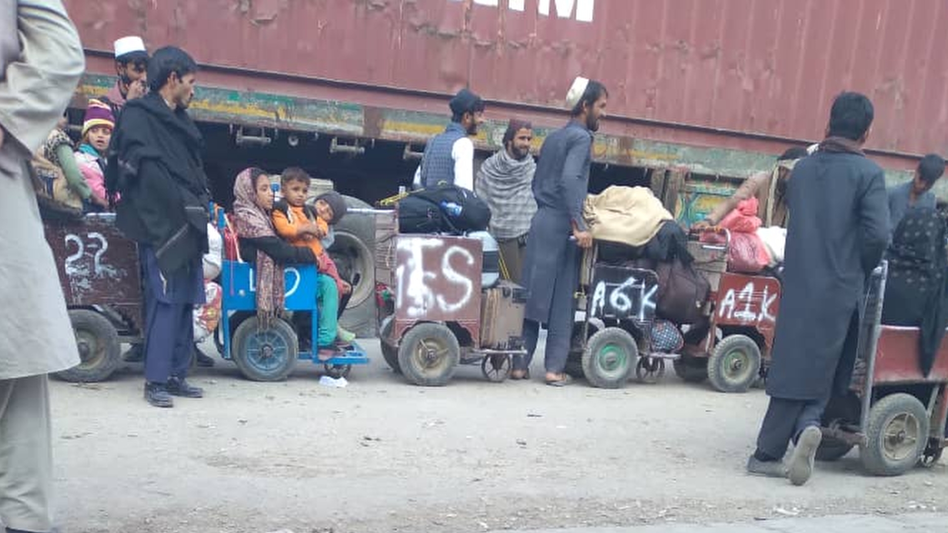 A photo of a group of people sitting in wheelchairs and trolleys.