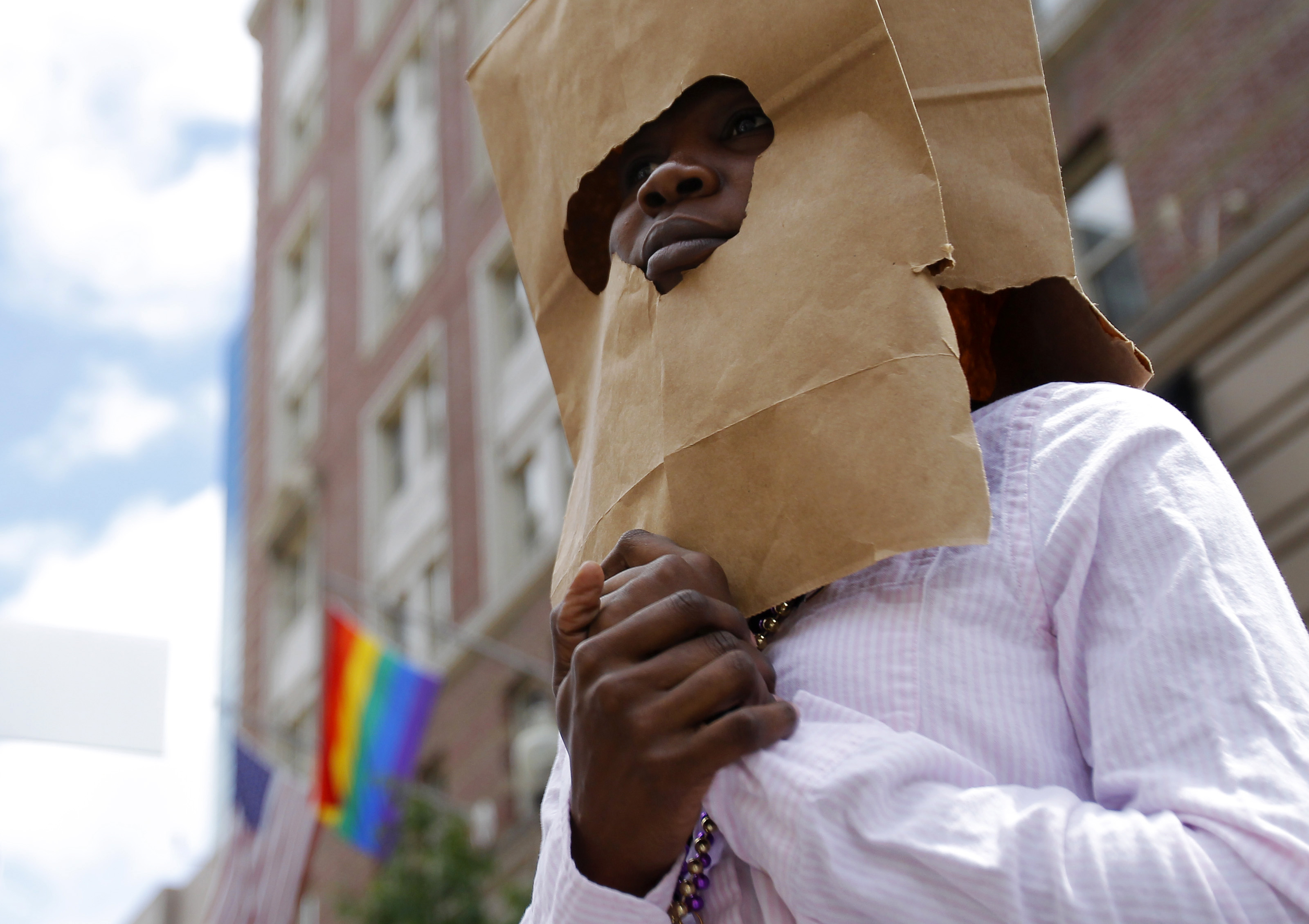 An asylum seeker from Uganda covers her face with a paper bag