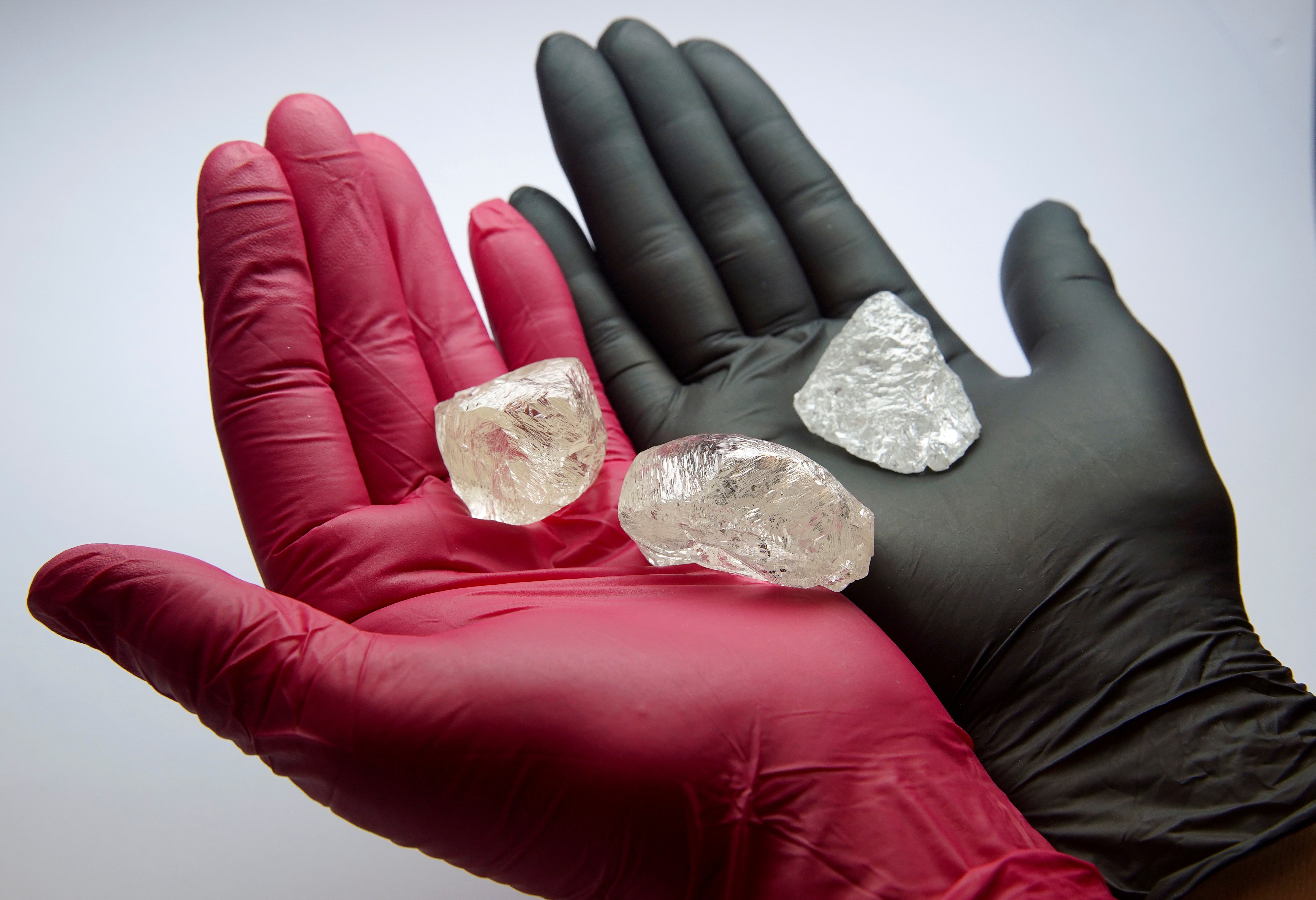 An employee shows gem-quality stones, including a rare 242-carat rough diamond that will be offered at the 100th international auction of Russian state-controlled diamond producer Alrosa, during a presentation in Moscow, Russia [Atyana Makeyeva/Reuters]