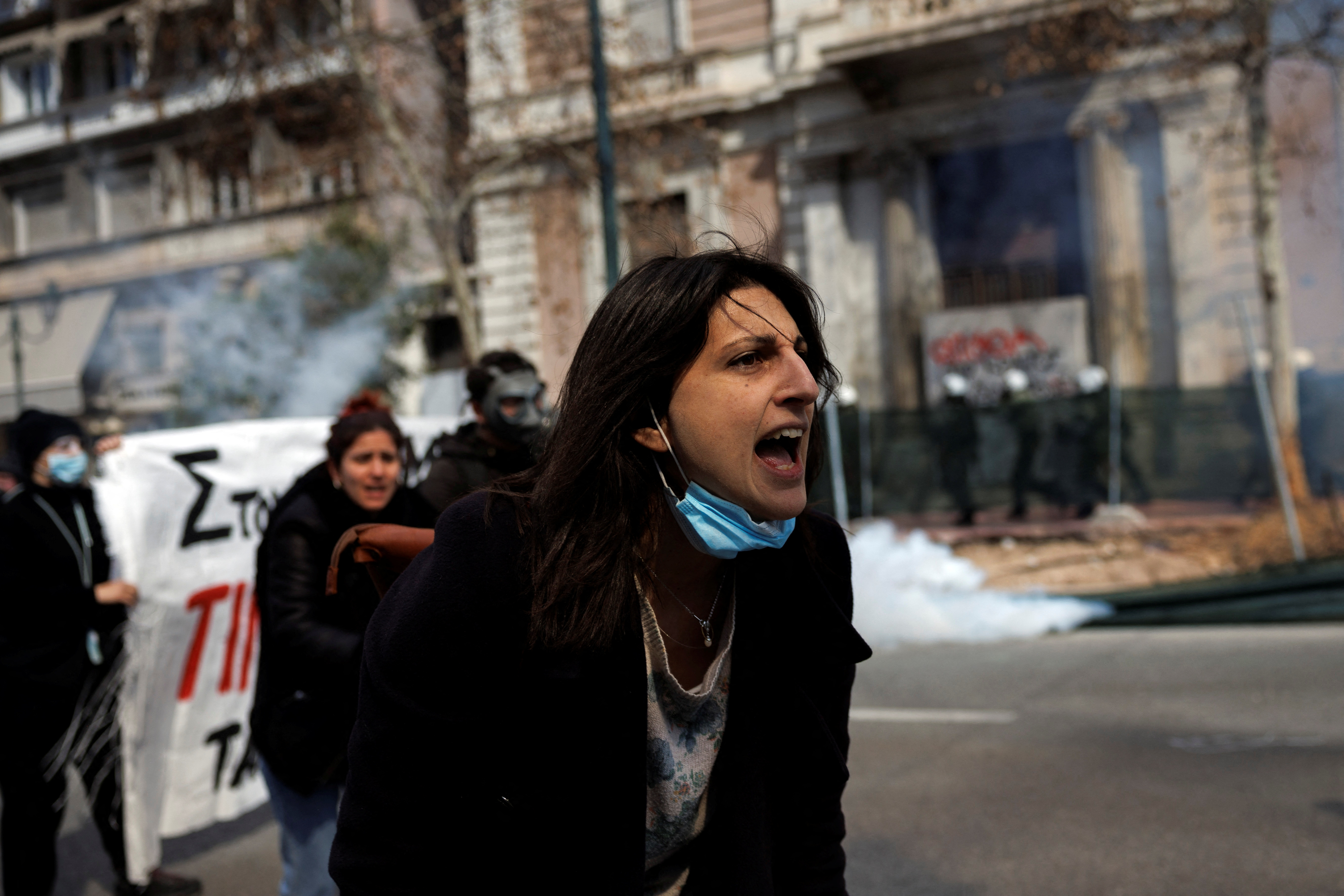 A protester reacts as clashes take place during a demonstration following the collision of two trains, near the city of Larissa, in Athens, Greece