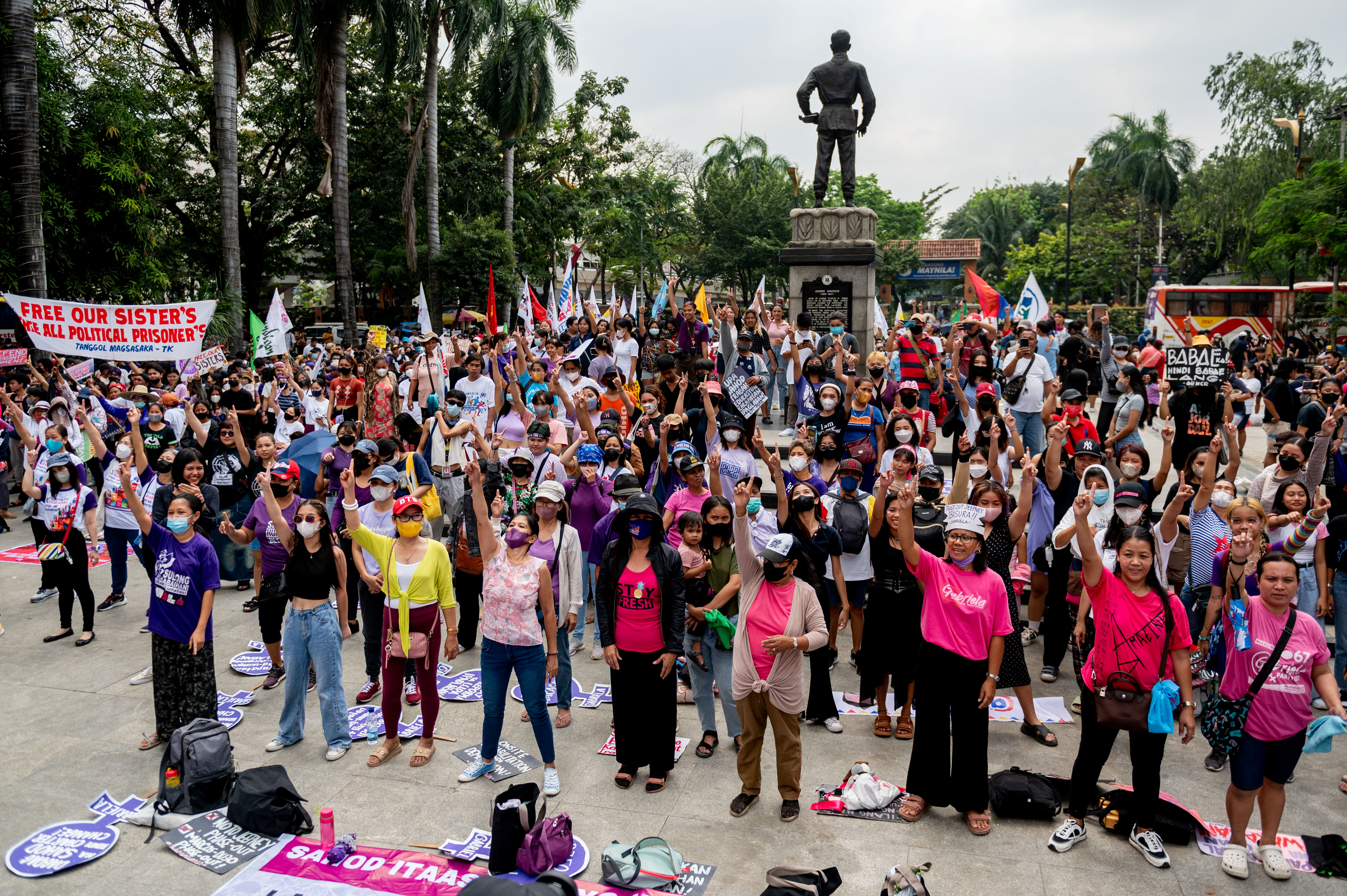 Filipino women and activists dance during a protest on Women's Day, in Manila, Philippines