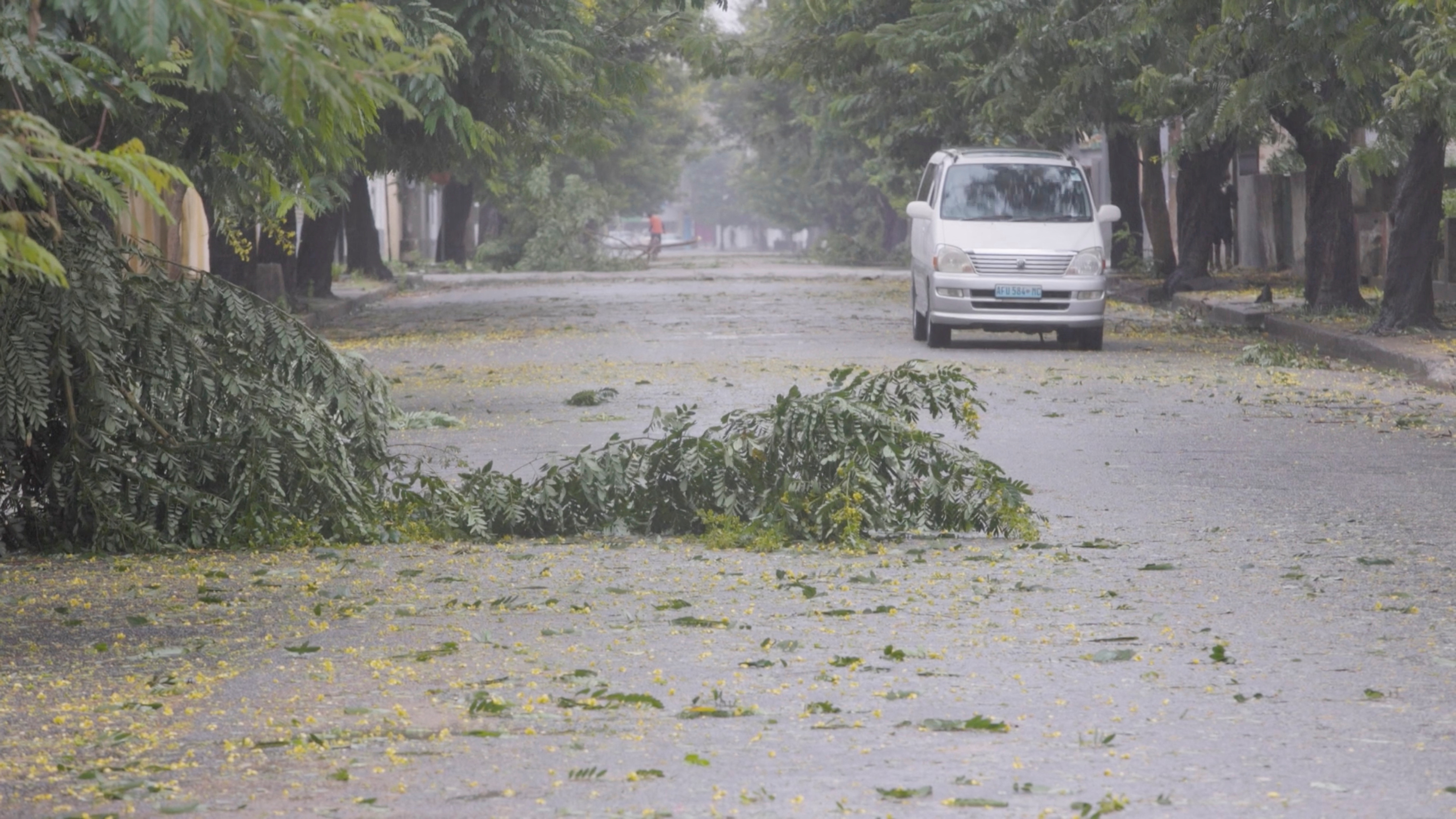 Fallen branches are seen on a street with a car not far off in the distance, as Cyclone Freddy is due to hit Mozambique again, in Quelimane, Zambezia.