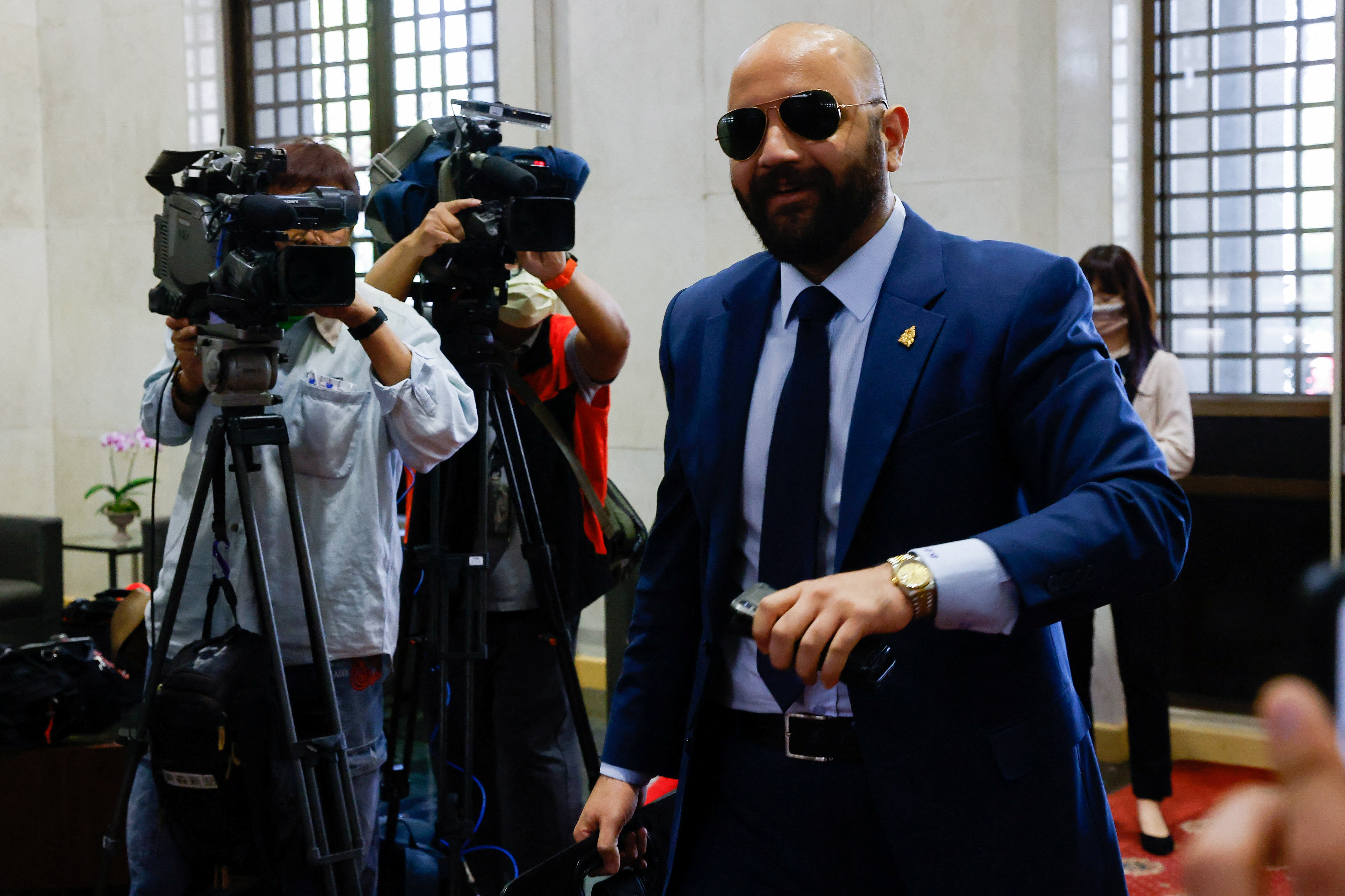 Harold Burgos, Honduras ambassador to Taiwan, arriving at the foreign ministry in Taipei. He is wearing a suit and dark glasses, and is being filmed by the media.