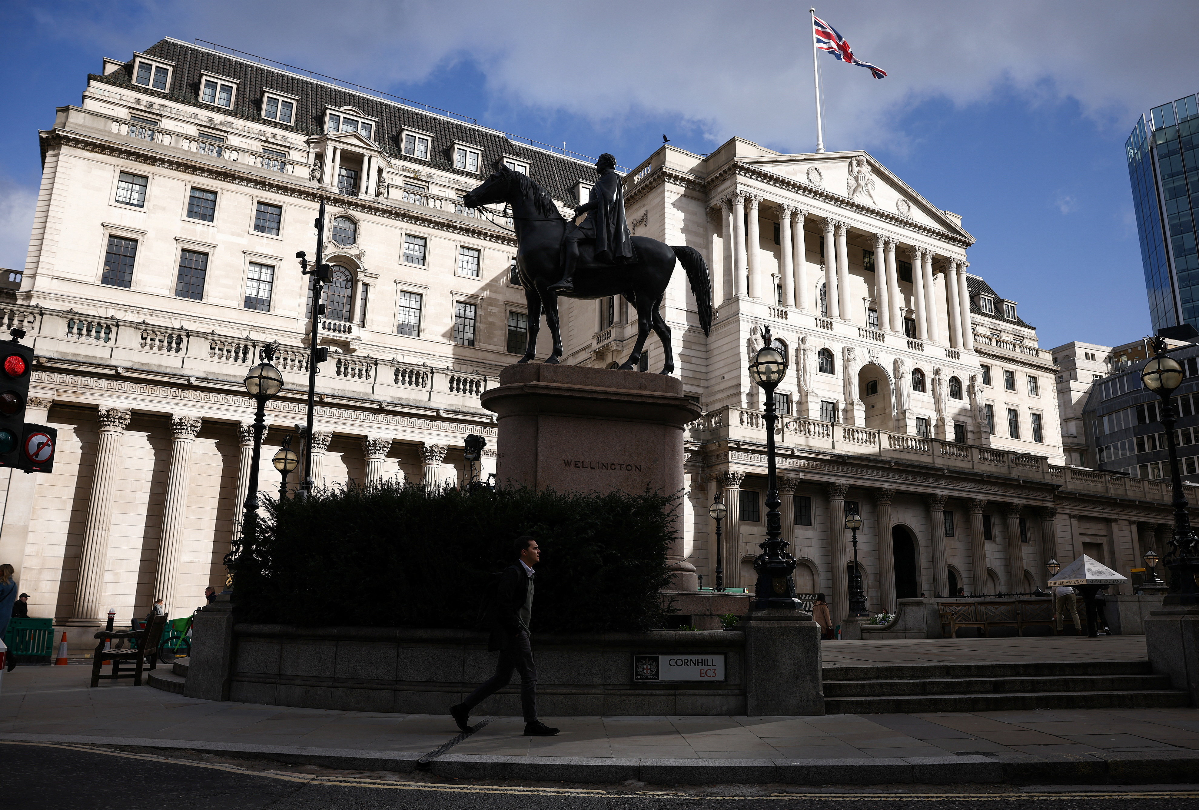 A person walks outside the Bank of England in the City of London financial district in London, Britain, March 23, 2023. REUTERS/Henry Nicholls