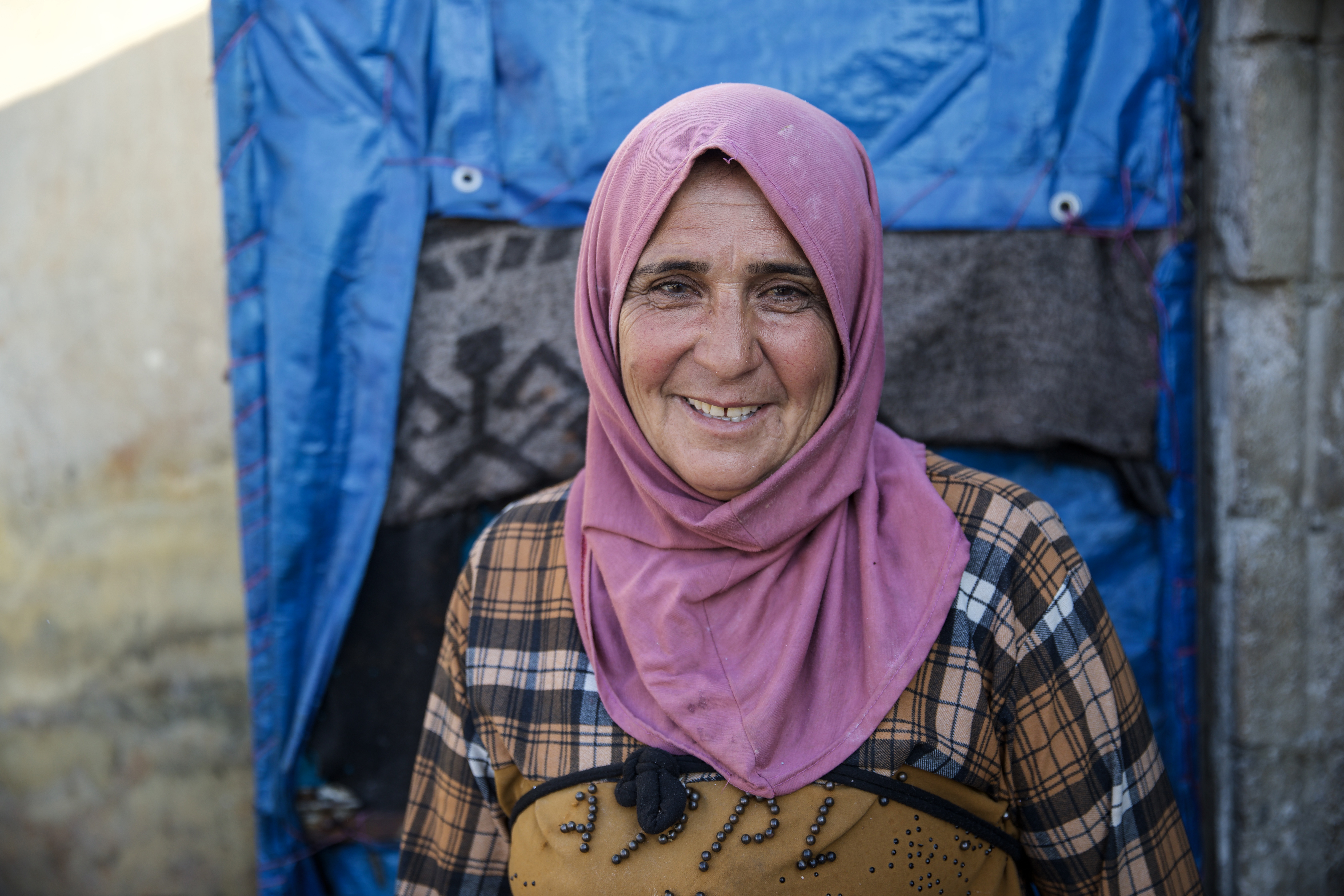 Fateem smiling at the camera warmly, in her pink headscarf